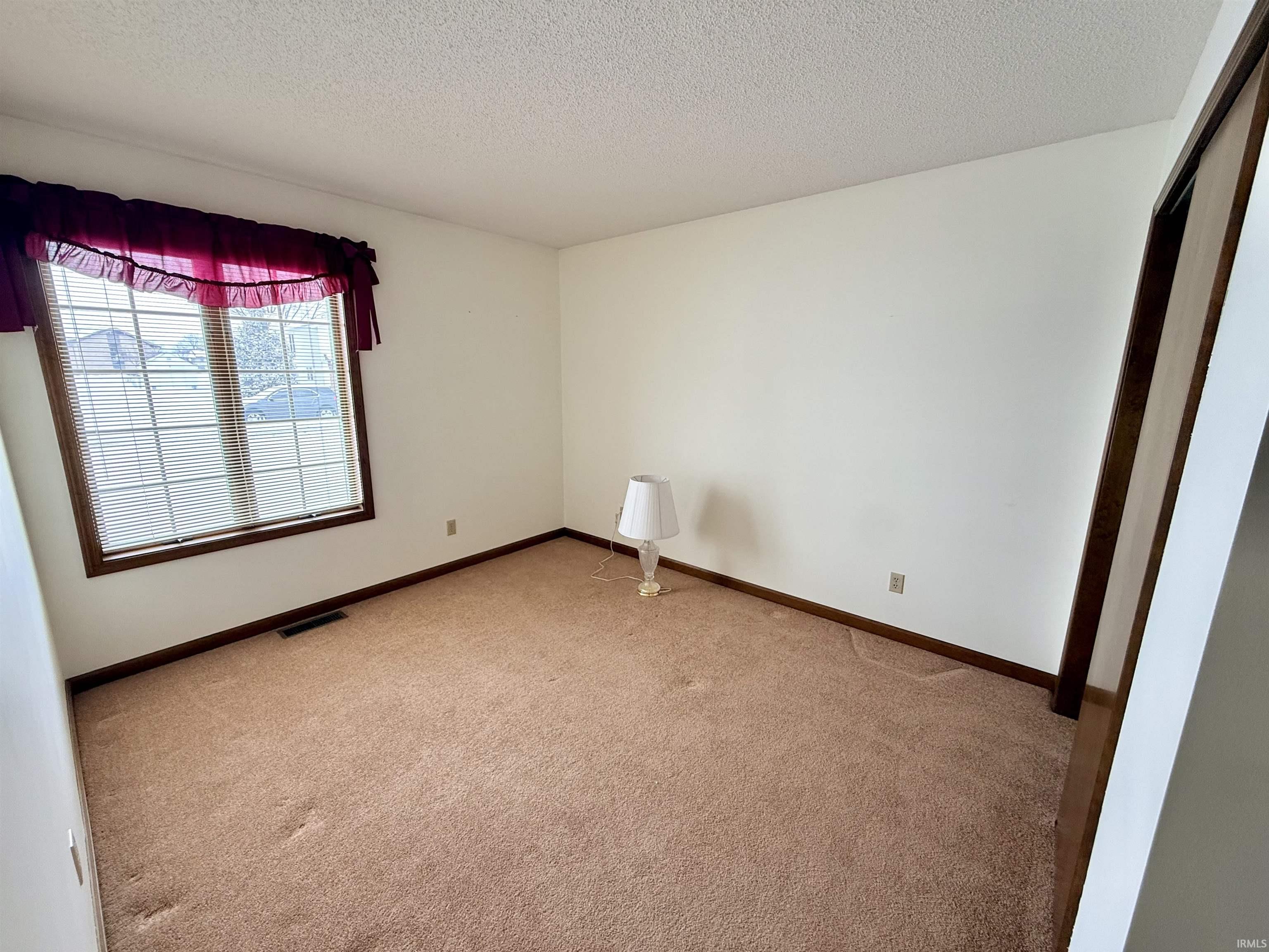 Spare room with carpet and a textured ceiling