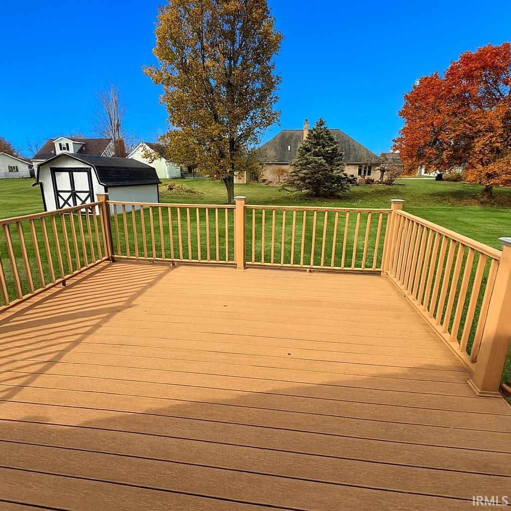 Deck featuring a lawn and a shed