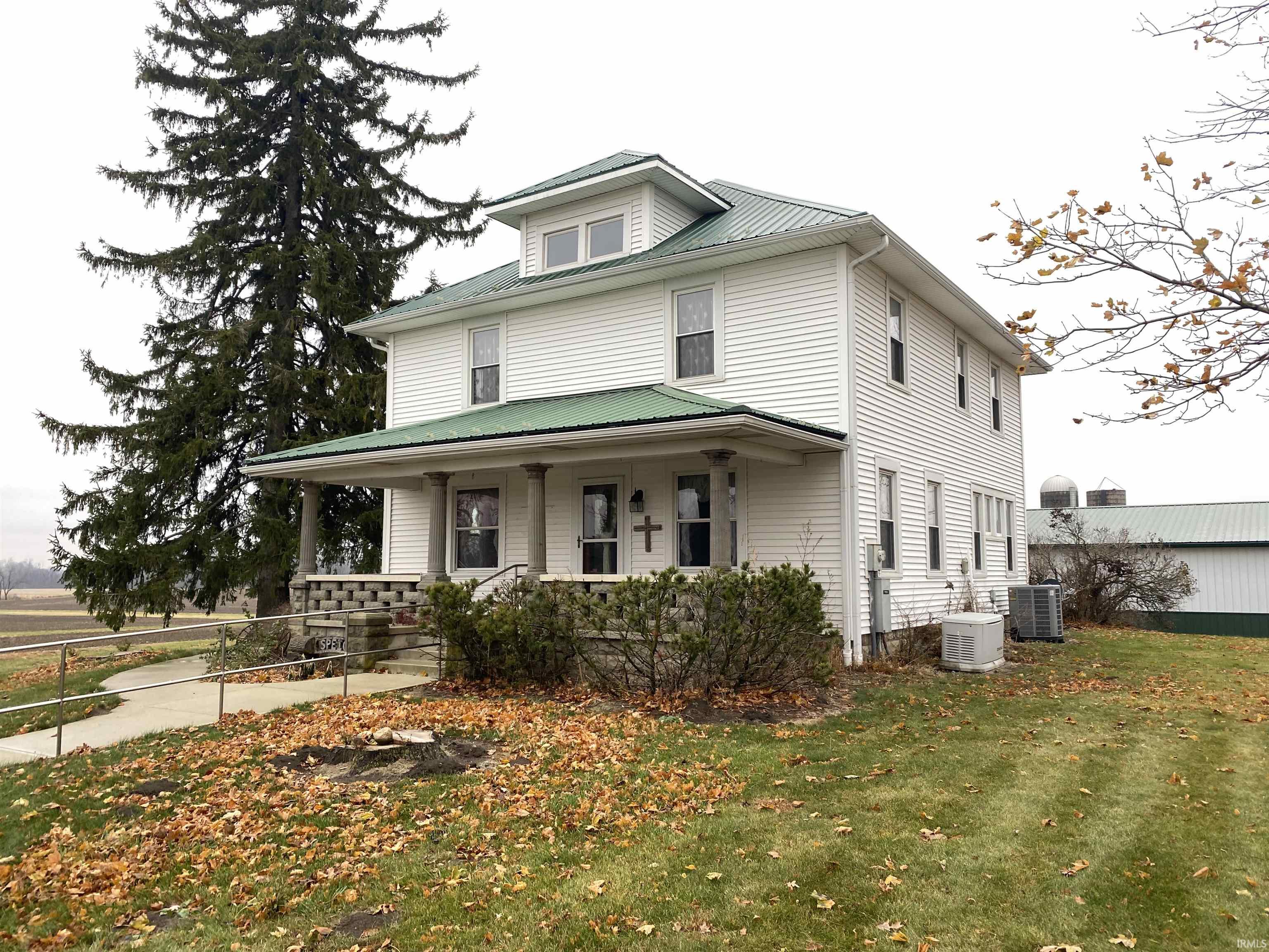 View of front of home featuring a porch, a front lawn, and a metal roof