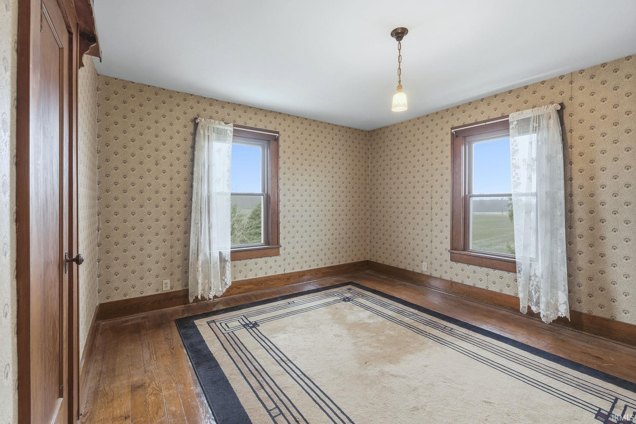 Empty room with wood-type flooring and healthy amount of natural light