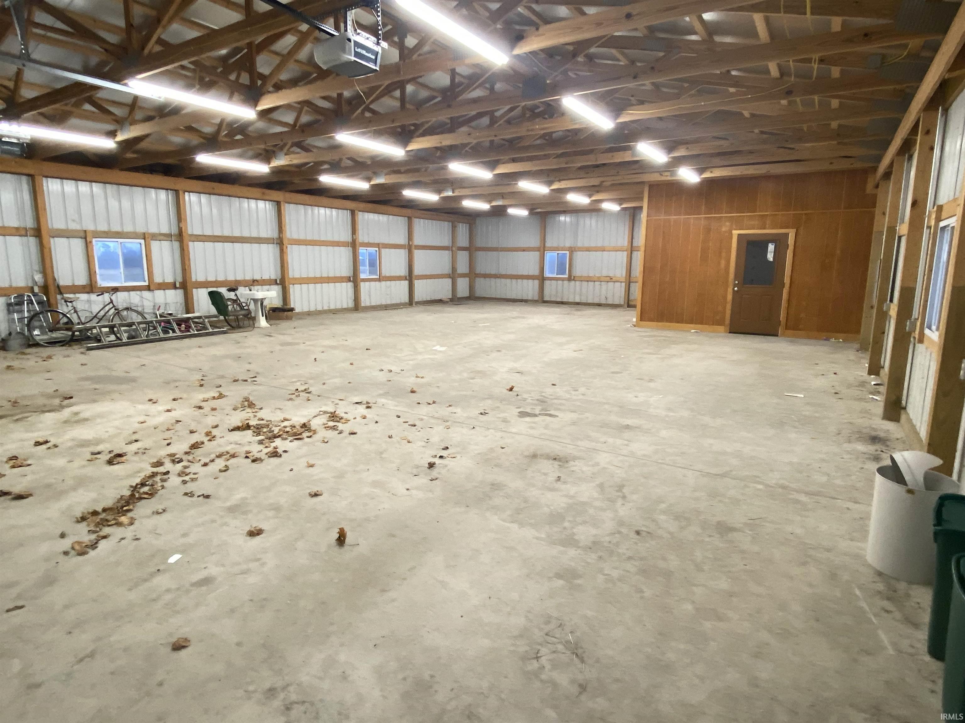 Miscellaneous room featuring unfinished concrete floors and a garage