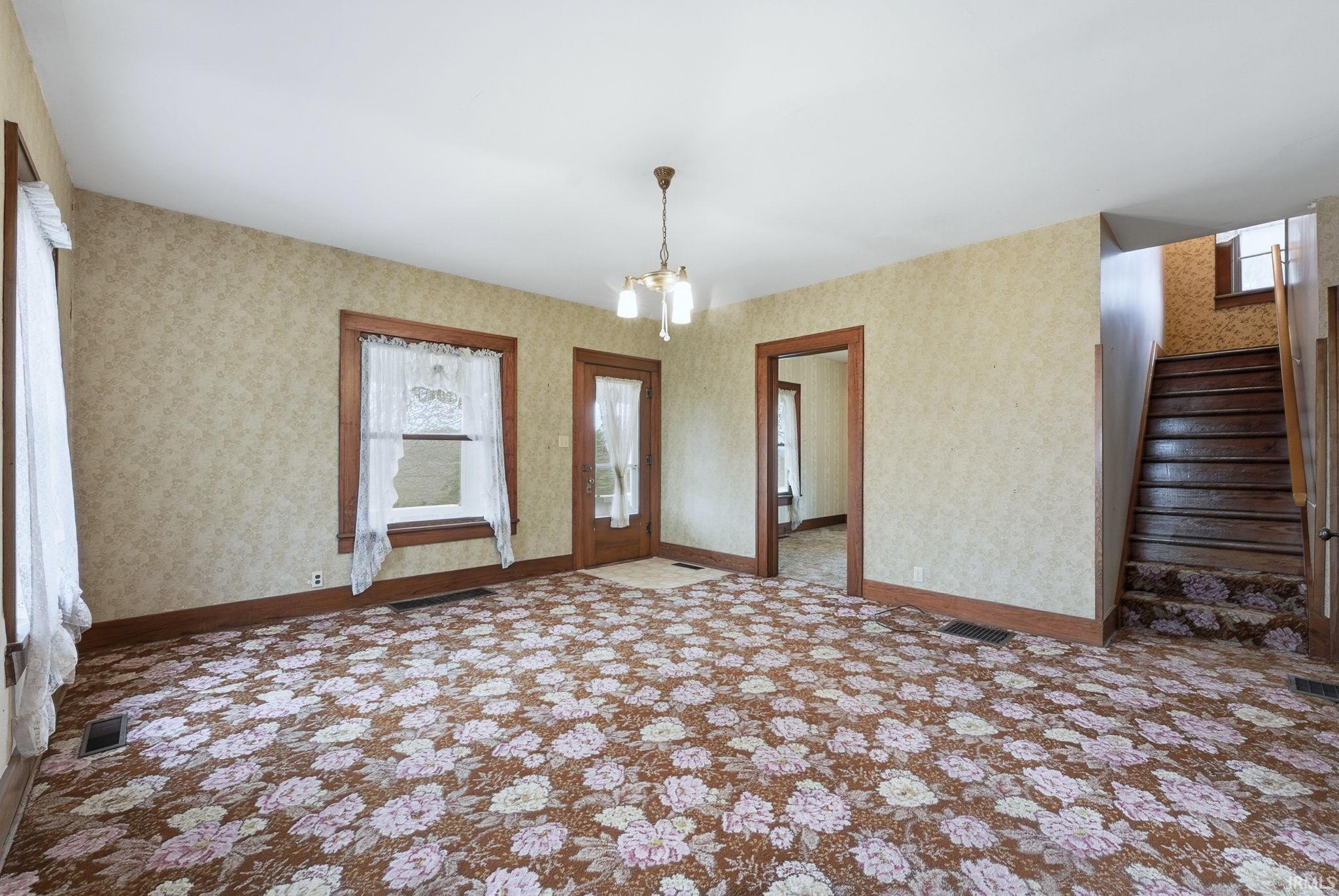 Entrance foyer featuring stairway and a chandelier