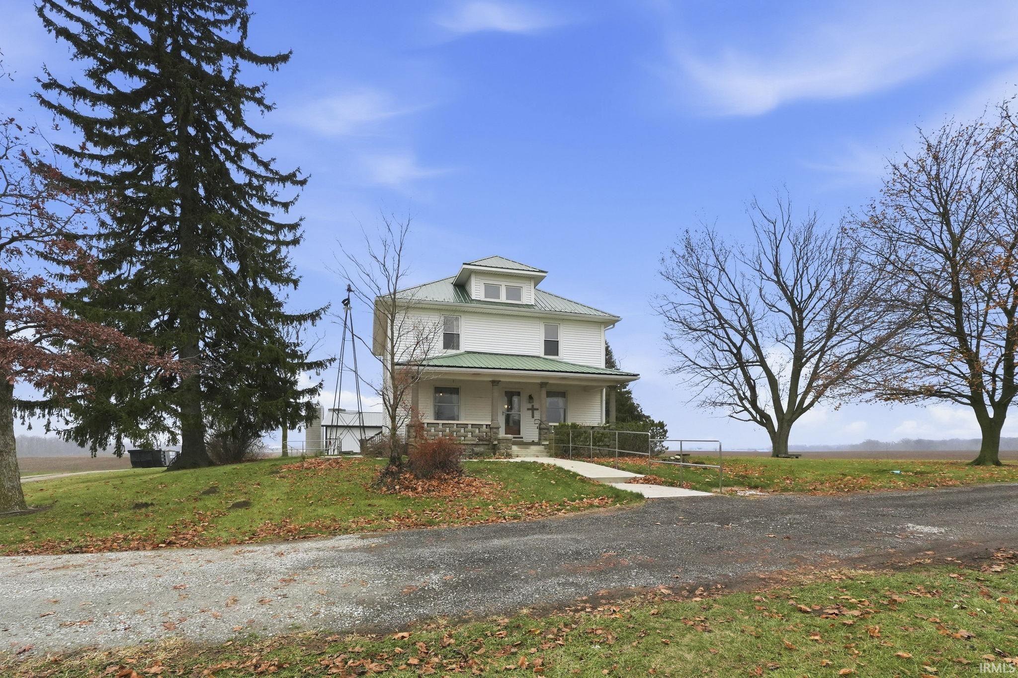 Traditional style home featuring a porch, a metal roof, and a front yard
