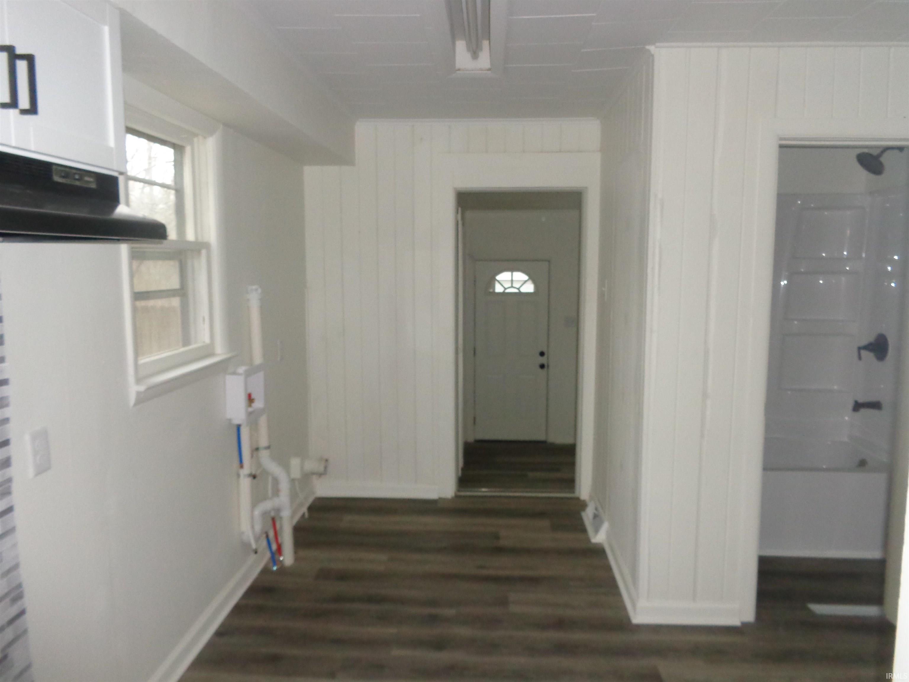 Hallway with wood walls and dark wood finished floors