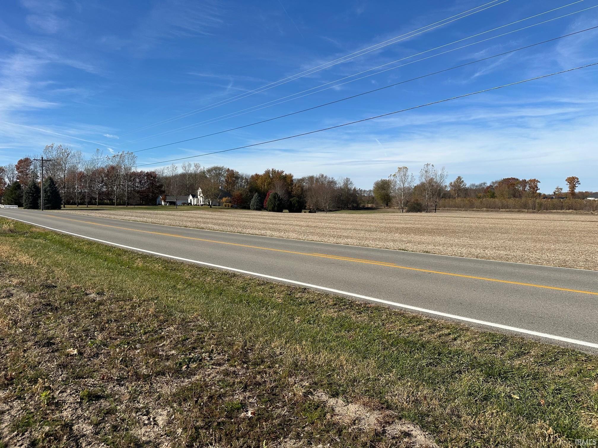 View of asphalt road with view of wooded area
