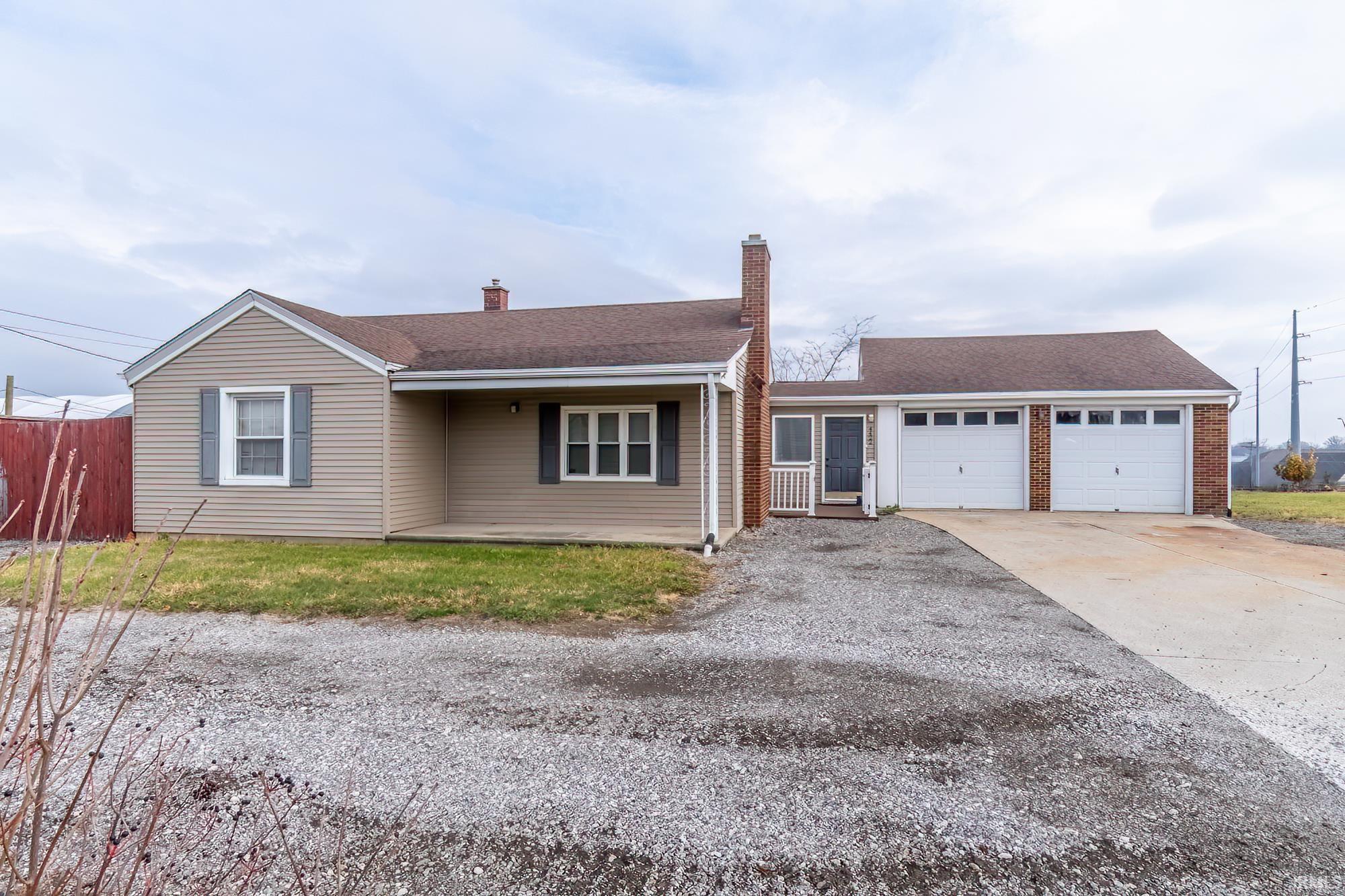 Ranch-style house with driveway, a chimney, roof with shingles, and an attached garage