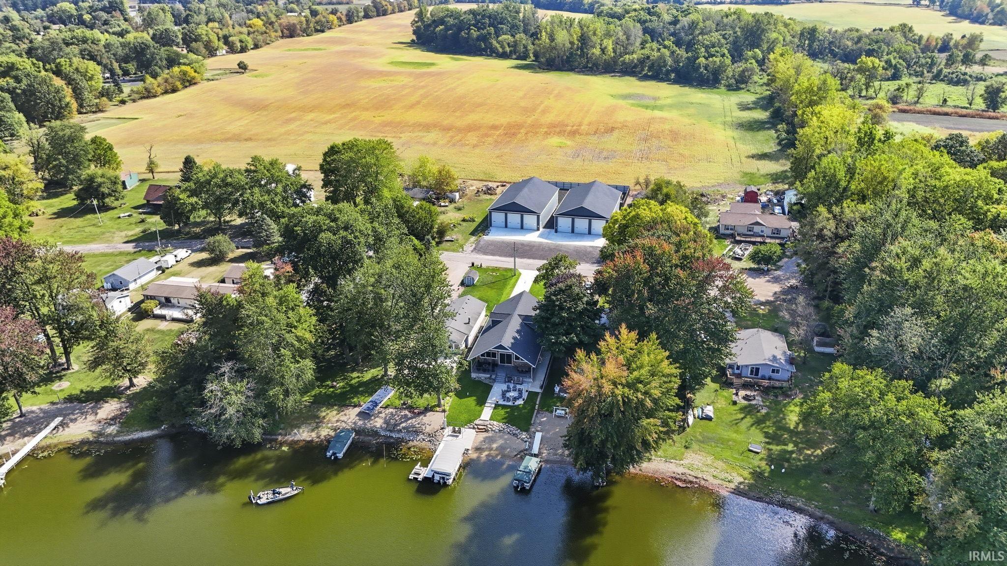 Aerial view of property's location with a nearby body of water and a tree filled landscape