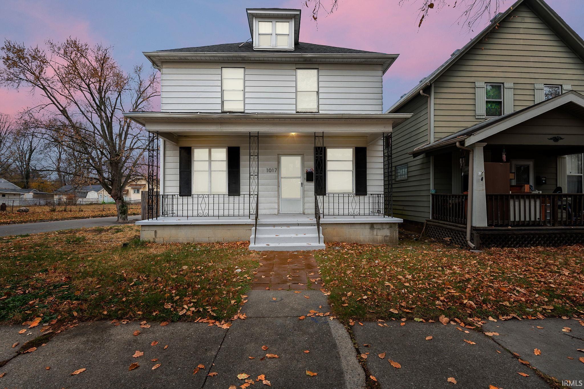 American foursquare style home featuring covered porch