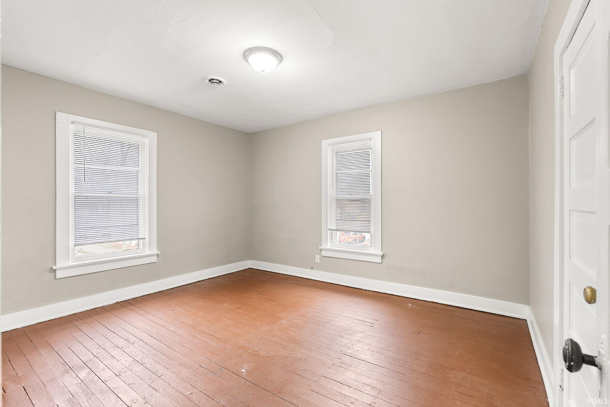 Unfurnished room featuring plenty of natural light and hardwood / wood-style flooring