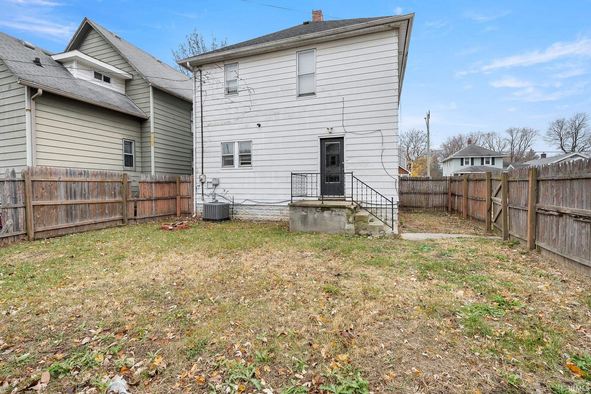 Rear view of house featuring a fenced backyard and a chimney