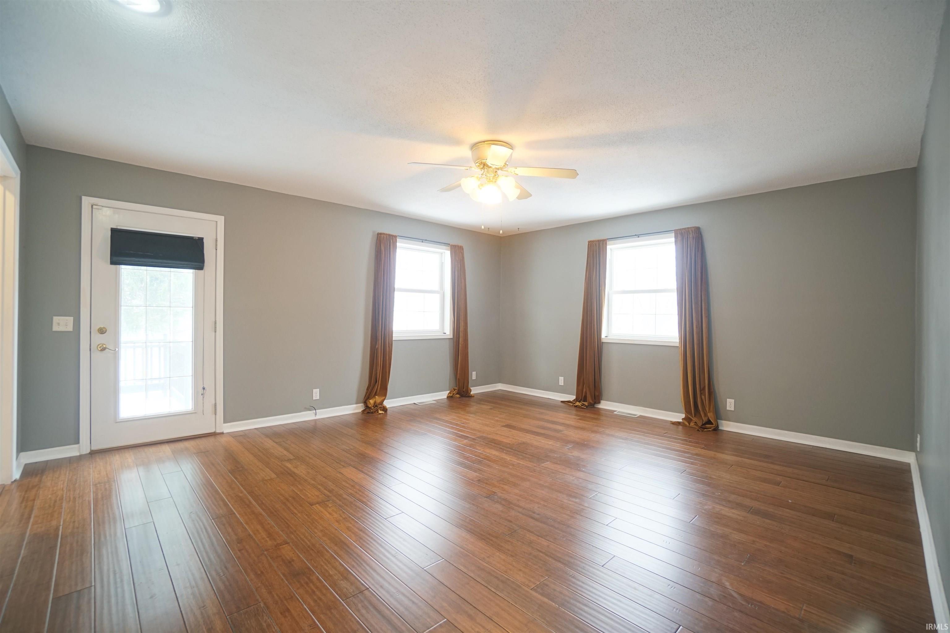 Empty room featuring wood-type flooring and ceiling fan