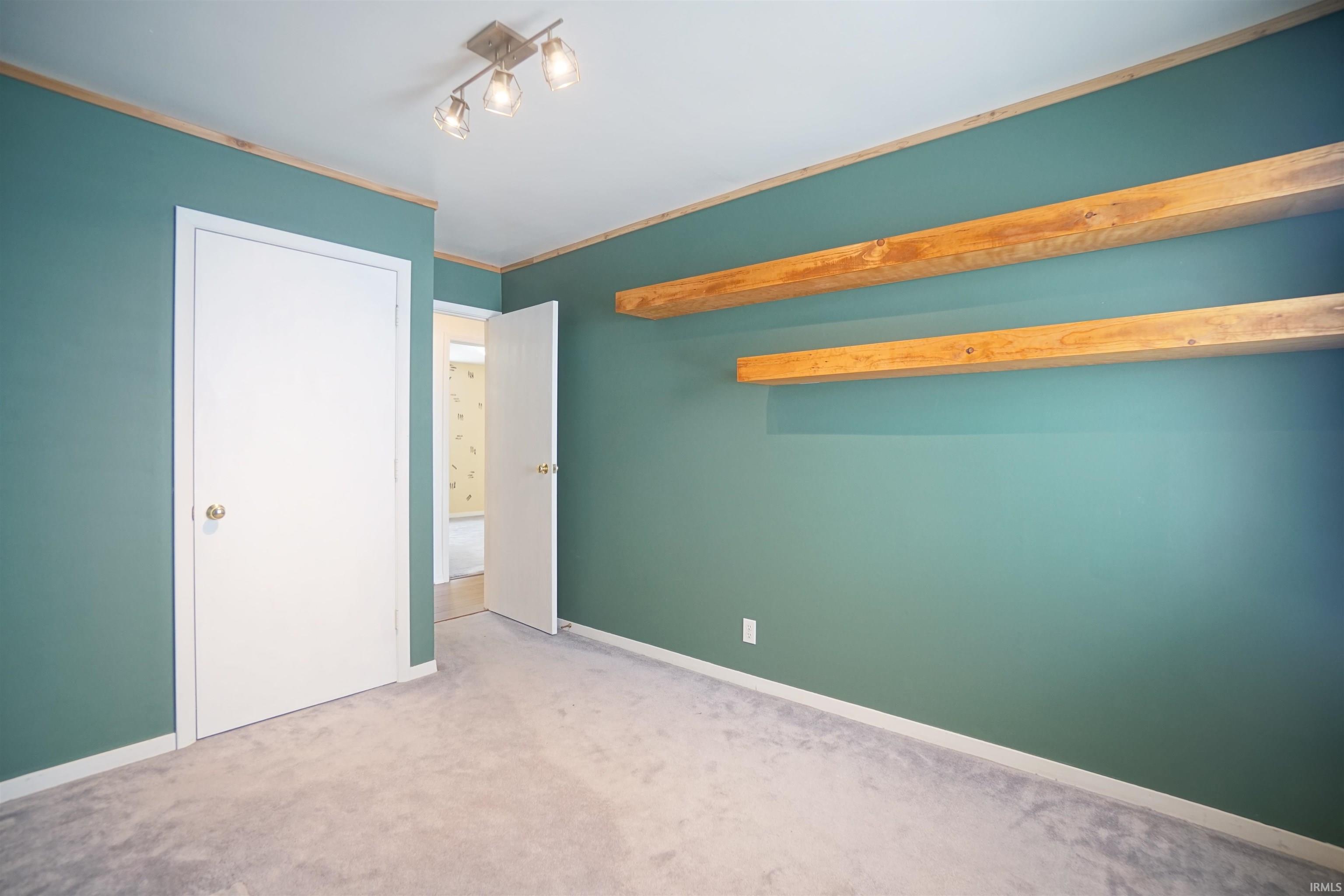 Unfurnished bedroom with carpet floors and baseboards