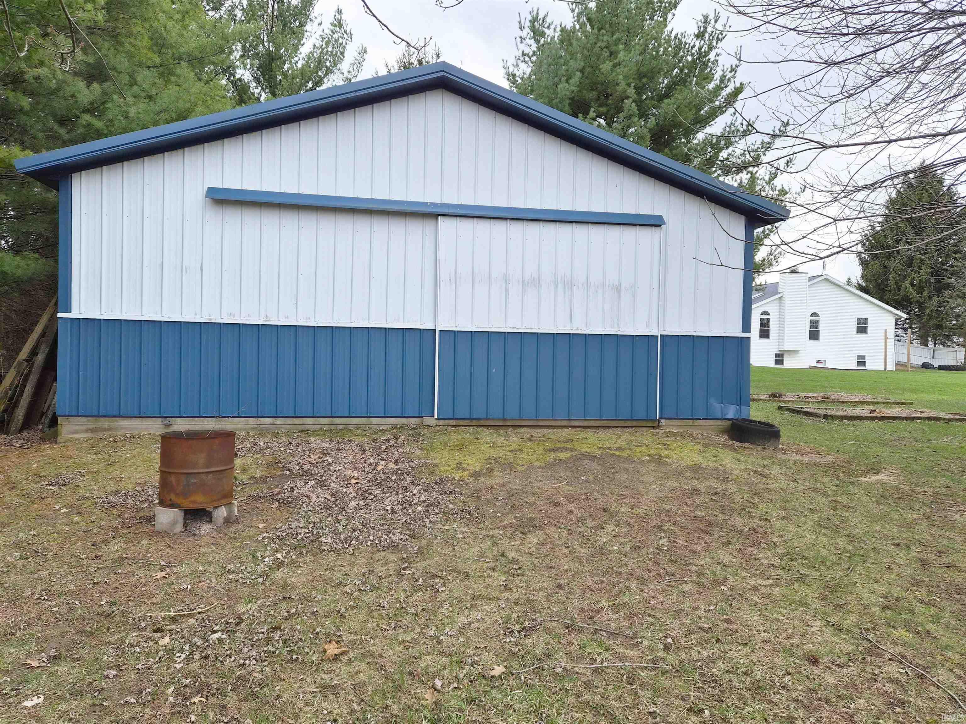 View of home's exterior with an outdoor structure and a pole building