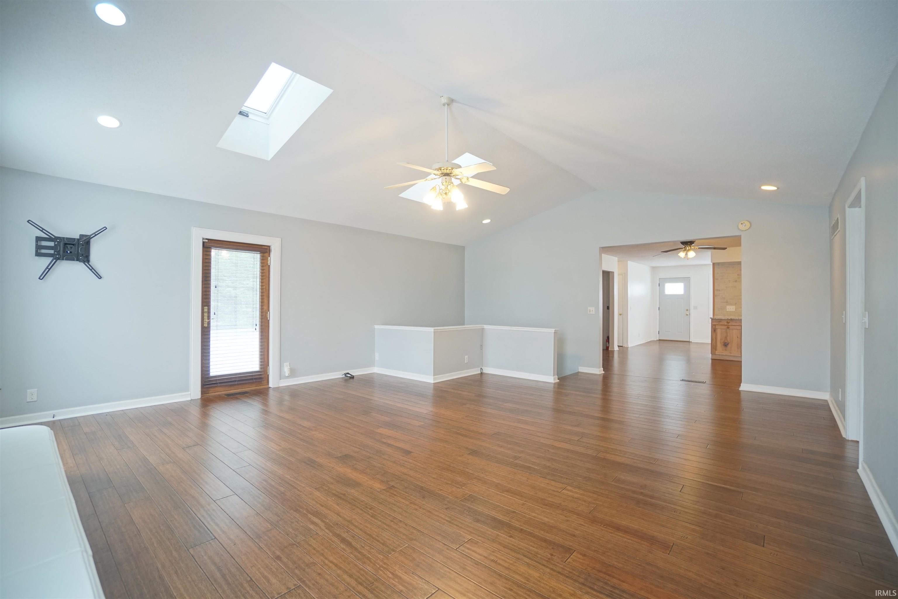 Spare room featuring recessed lighting, lofted ceiling, dark wood-type flooring, a ceiling fan, and a skylight