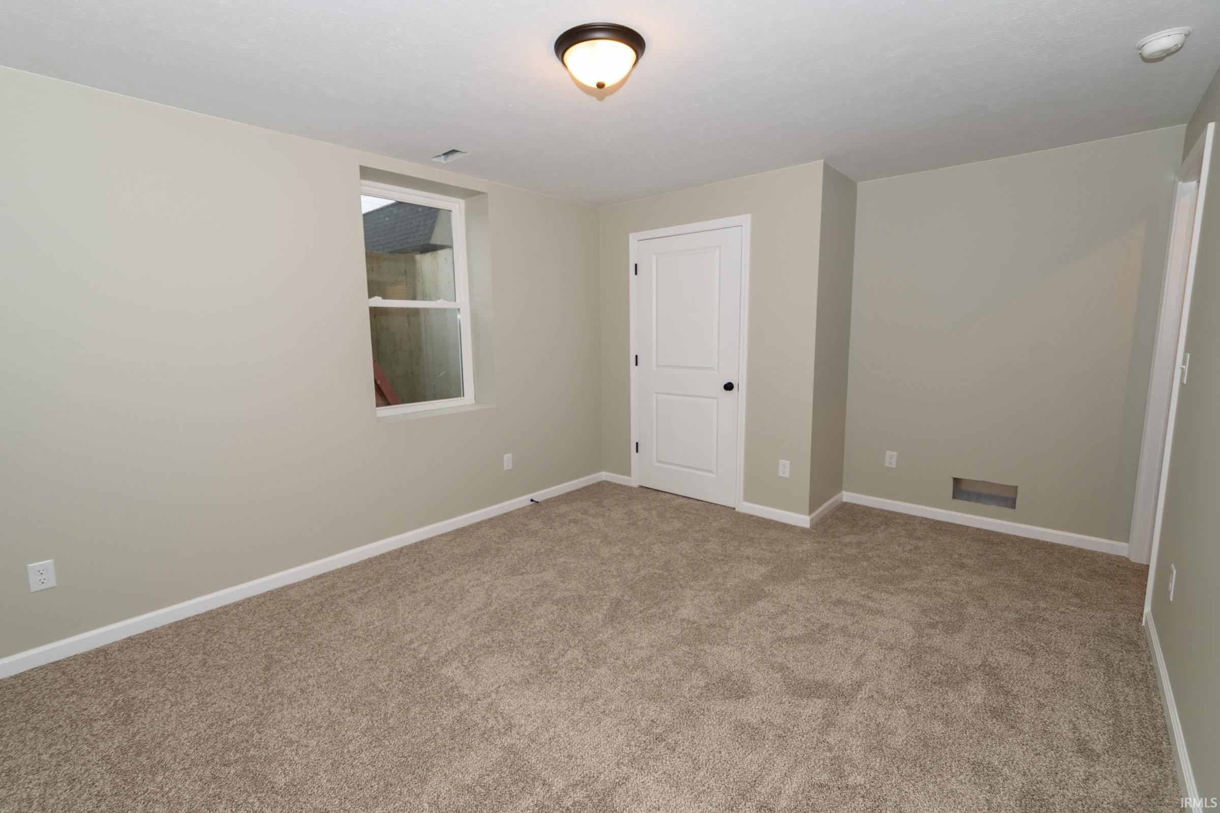 Unfurnished room with light colored carpet and baseboards