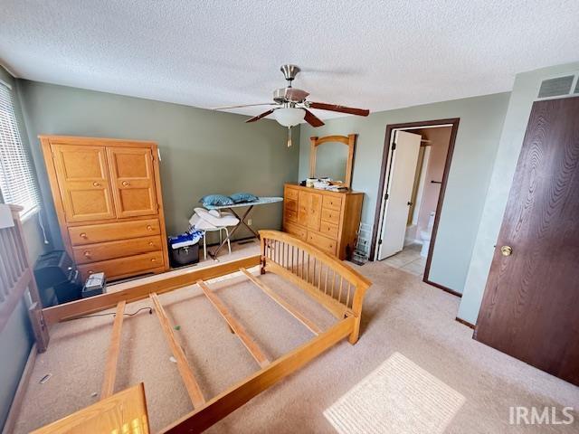 Carpeted bedroom with ceiling fan and a textured ceiling