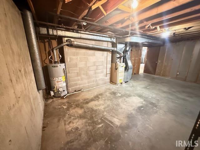 Unfinished below grade area with heating unit and gas water heater
