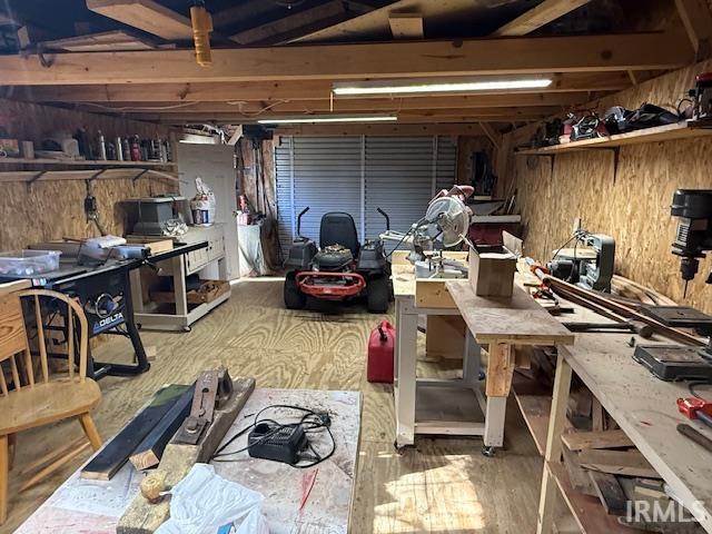 Garage featuring a workshop area and wood walls
