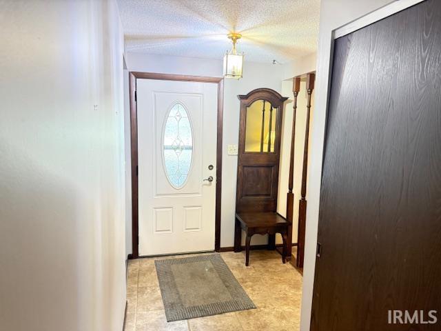 Entrance foyer with a textured ceiling and baseboards