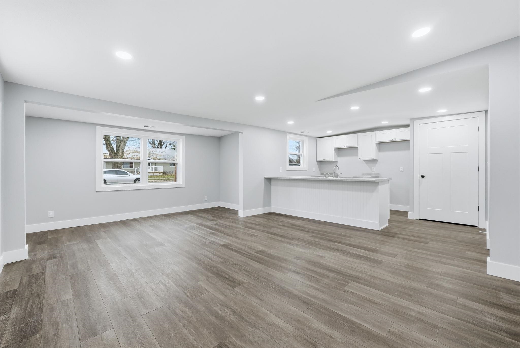 Unfurnished living room with dark wood-style flooring and recessed lighting