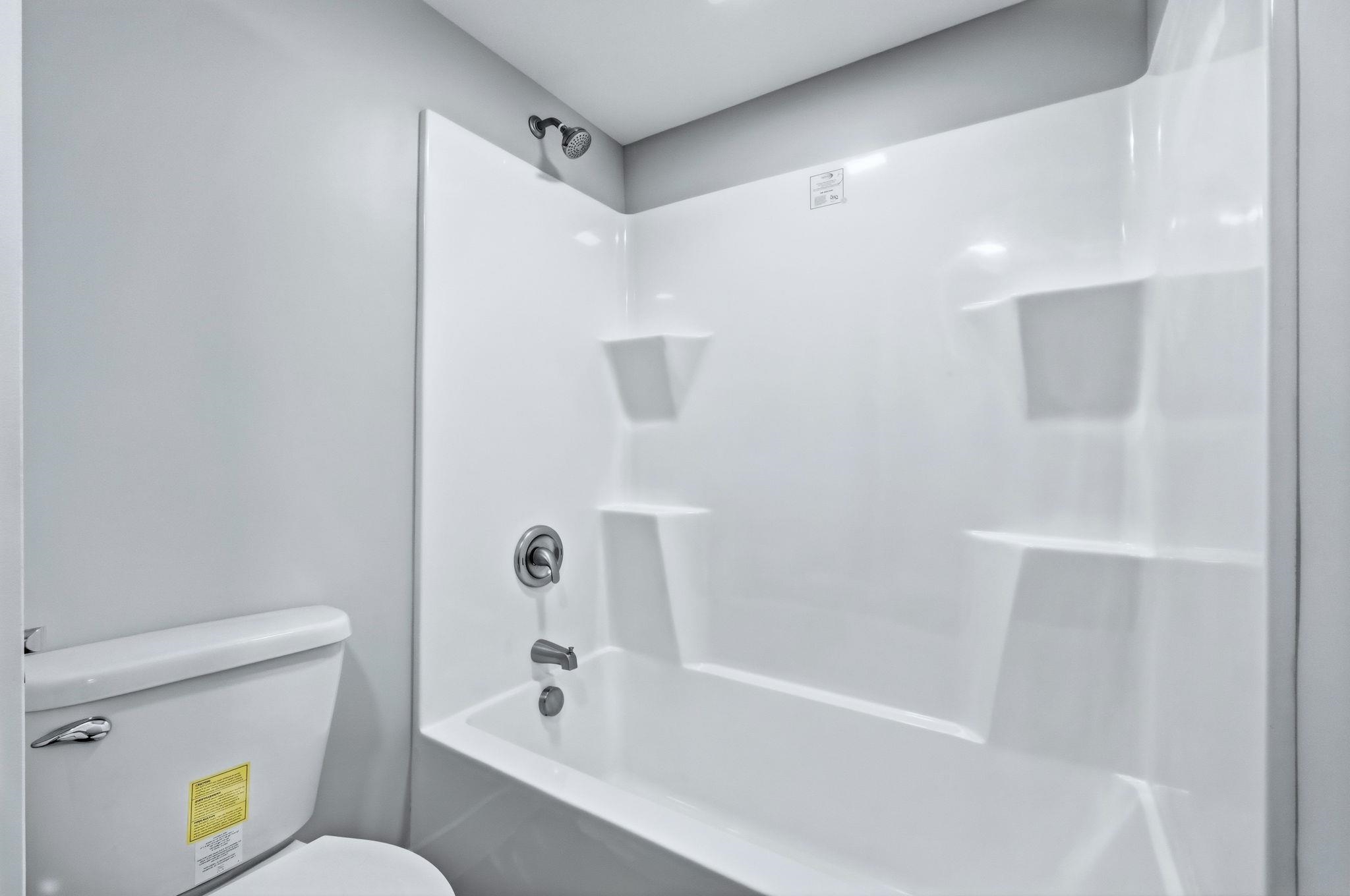 Full bathroom featuring washtub / shower combination and toilet