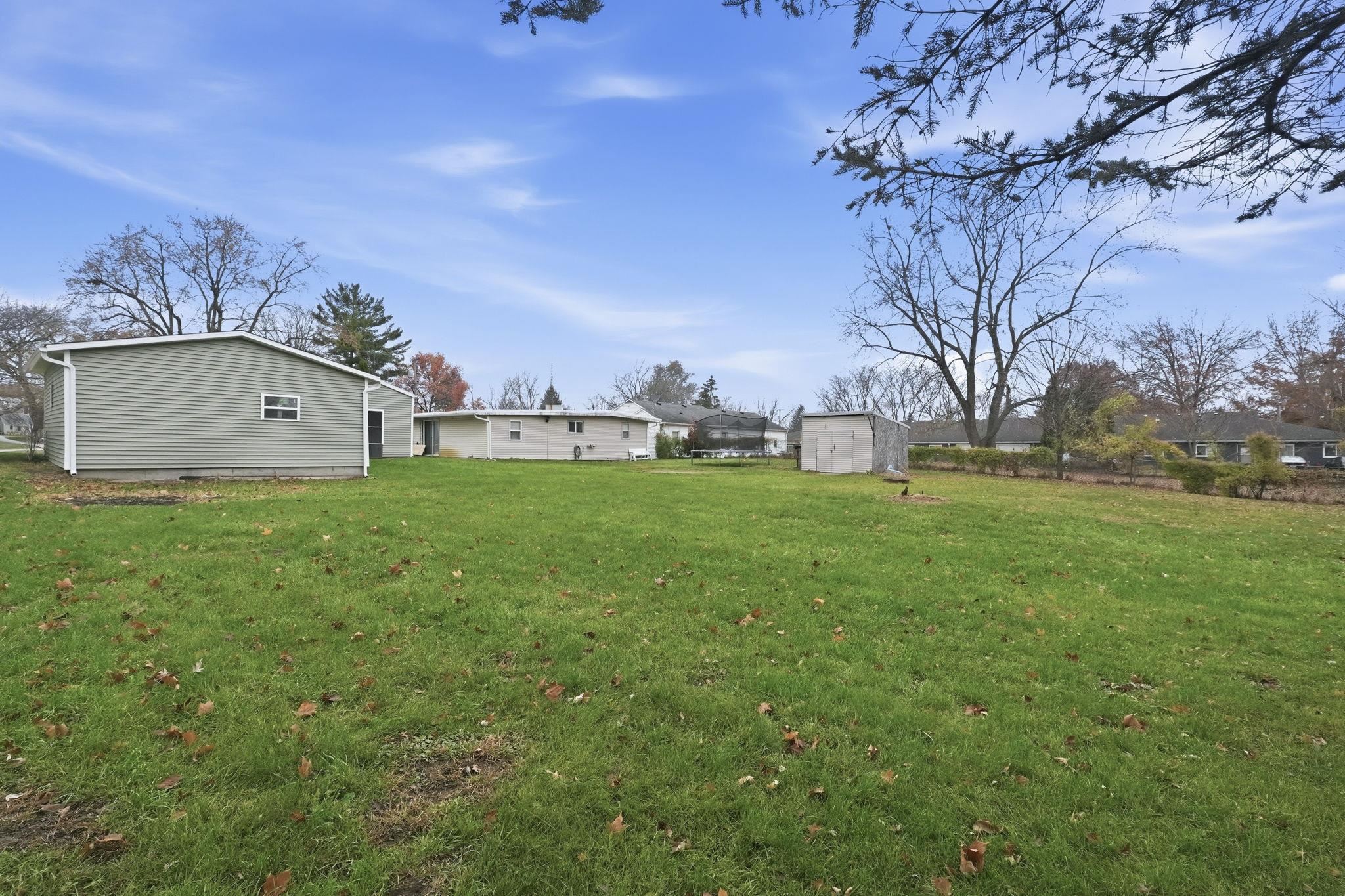 View of grassy yard featuring a shed