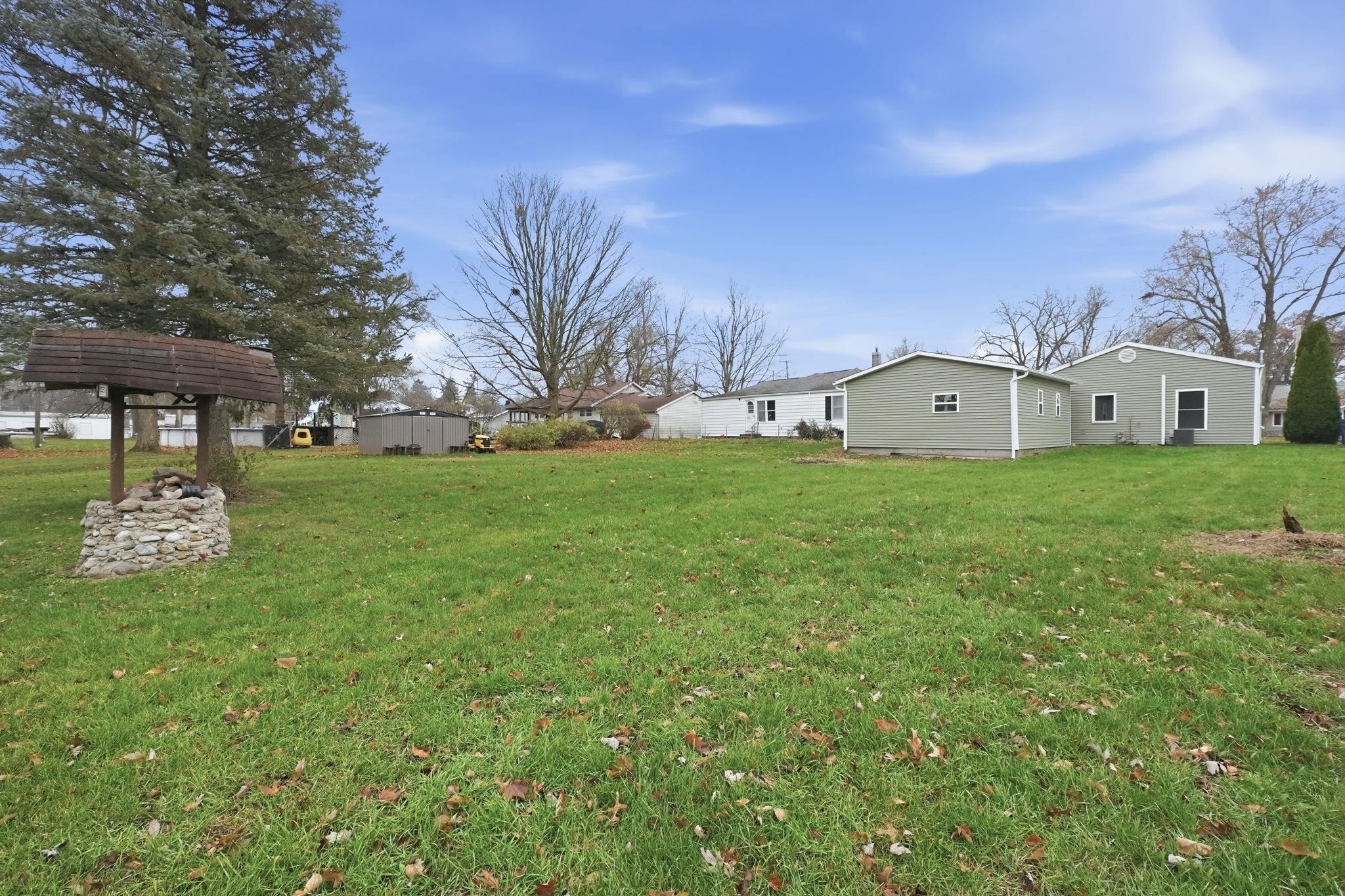 View of grassy yard with a storage shed