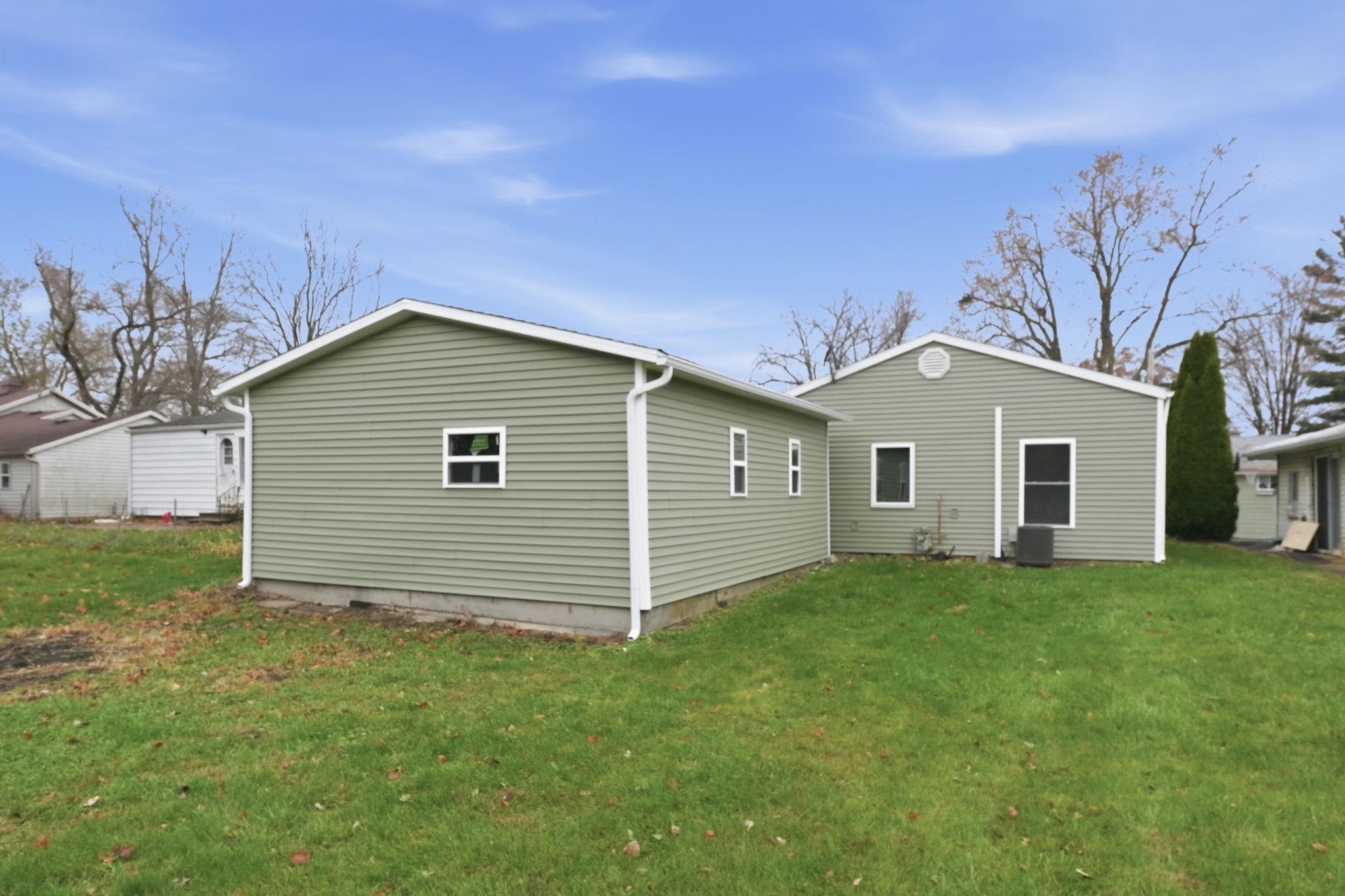 Back of property with a lawn