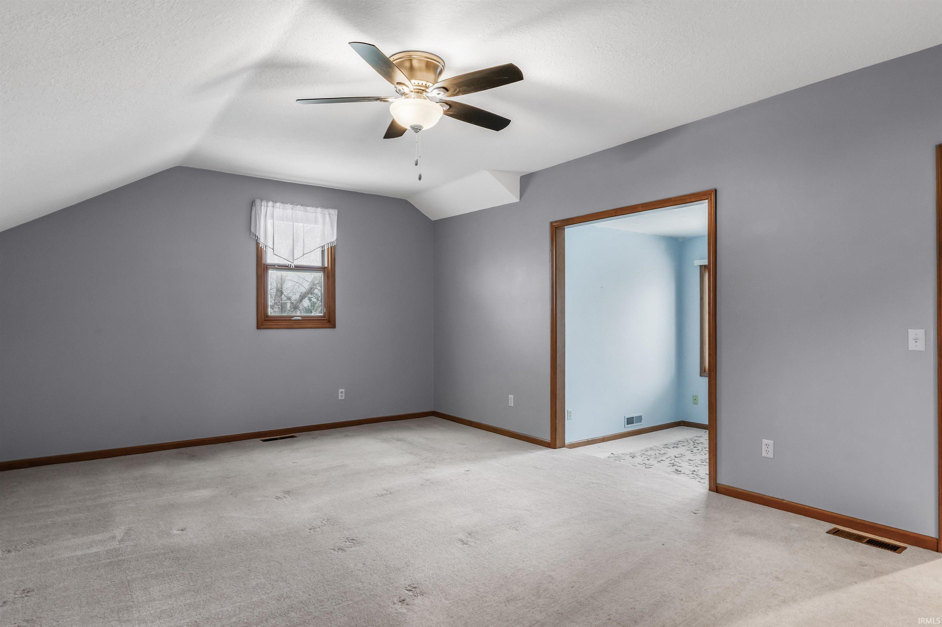 Bonus room featuring vaulted ceiling, light carpet, ceiling fan, and a textured ceiling
