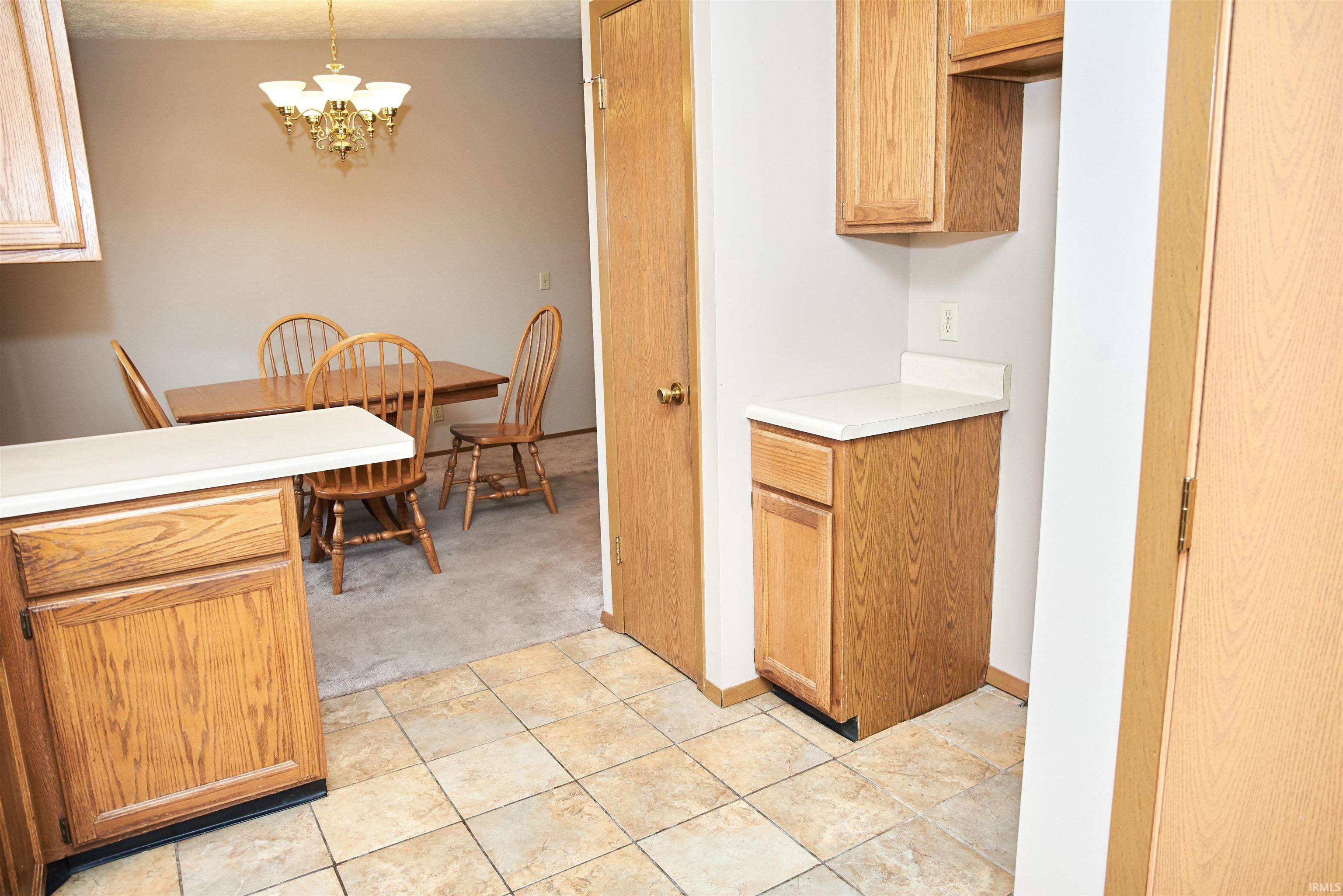 Kitchen with light countertops, hanging light fixtures, and a chandelier
