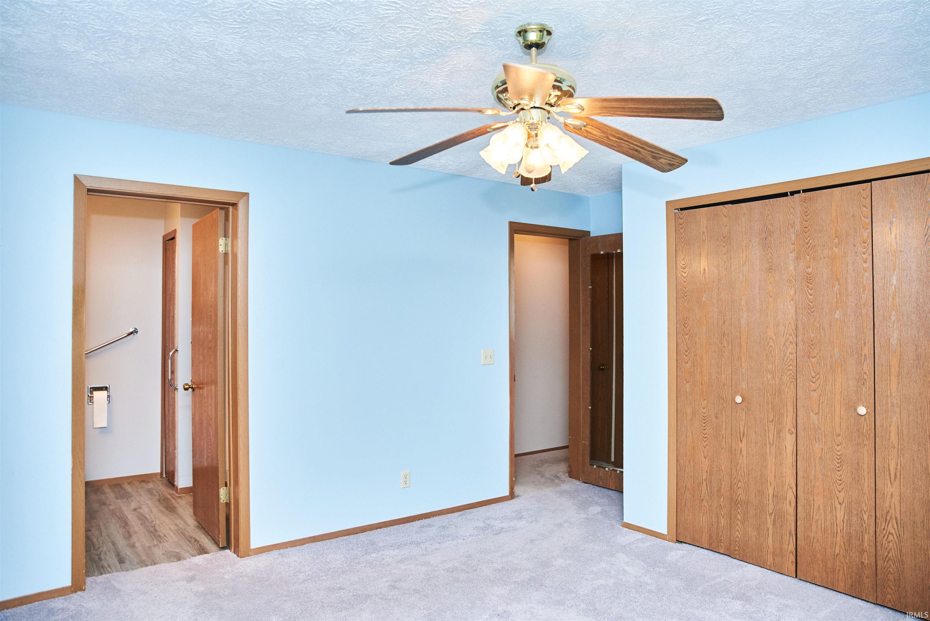 Unfurnished bedroom featuring carpet floors, a textured ceiling, a closet, and ceiling fan