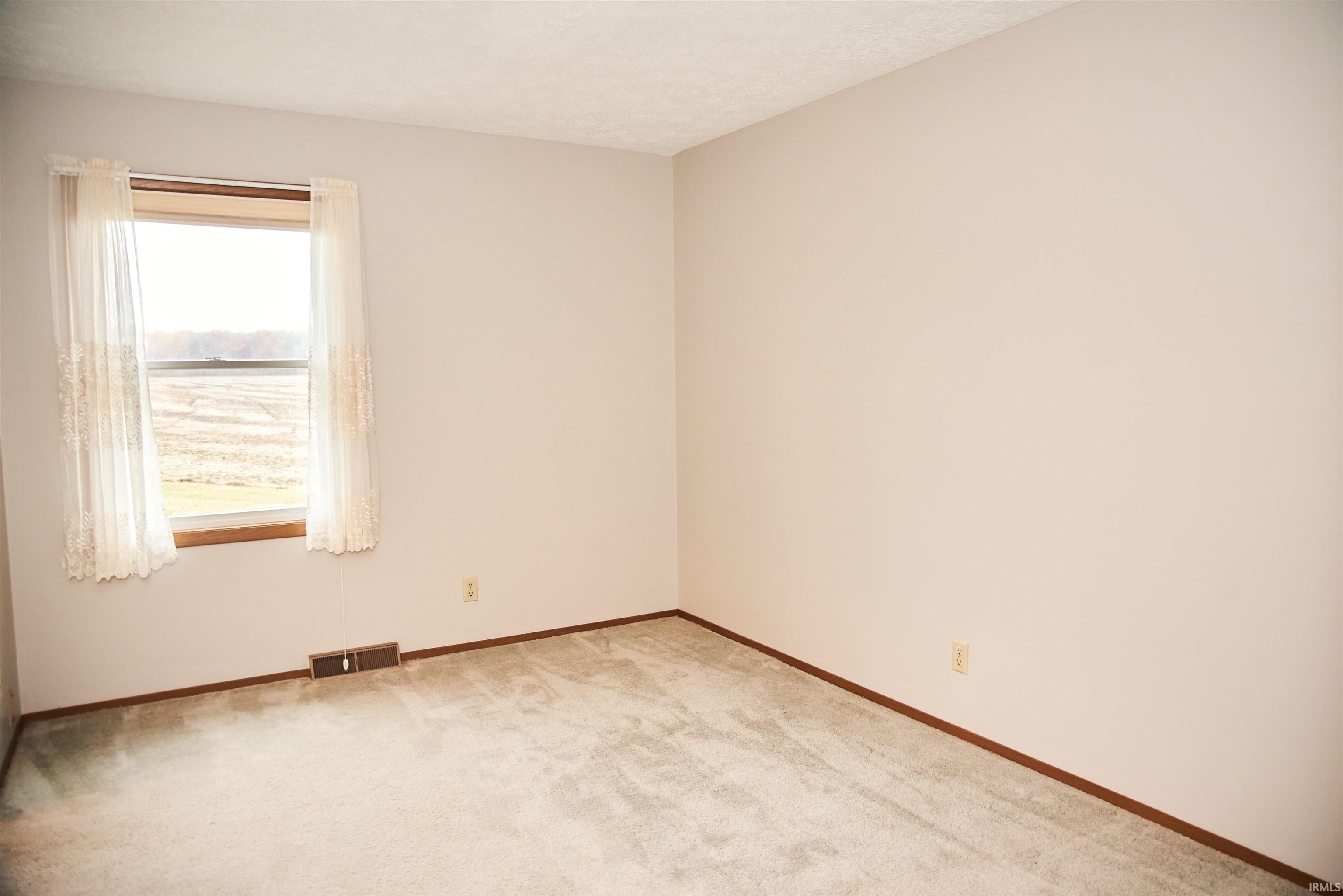 Unfurnished room featuring carpet and a textured ceiling