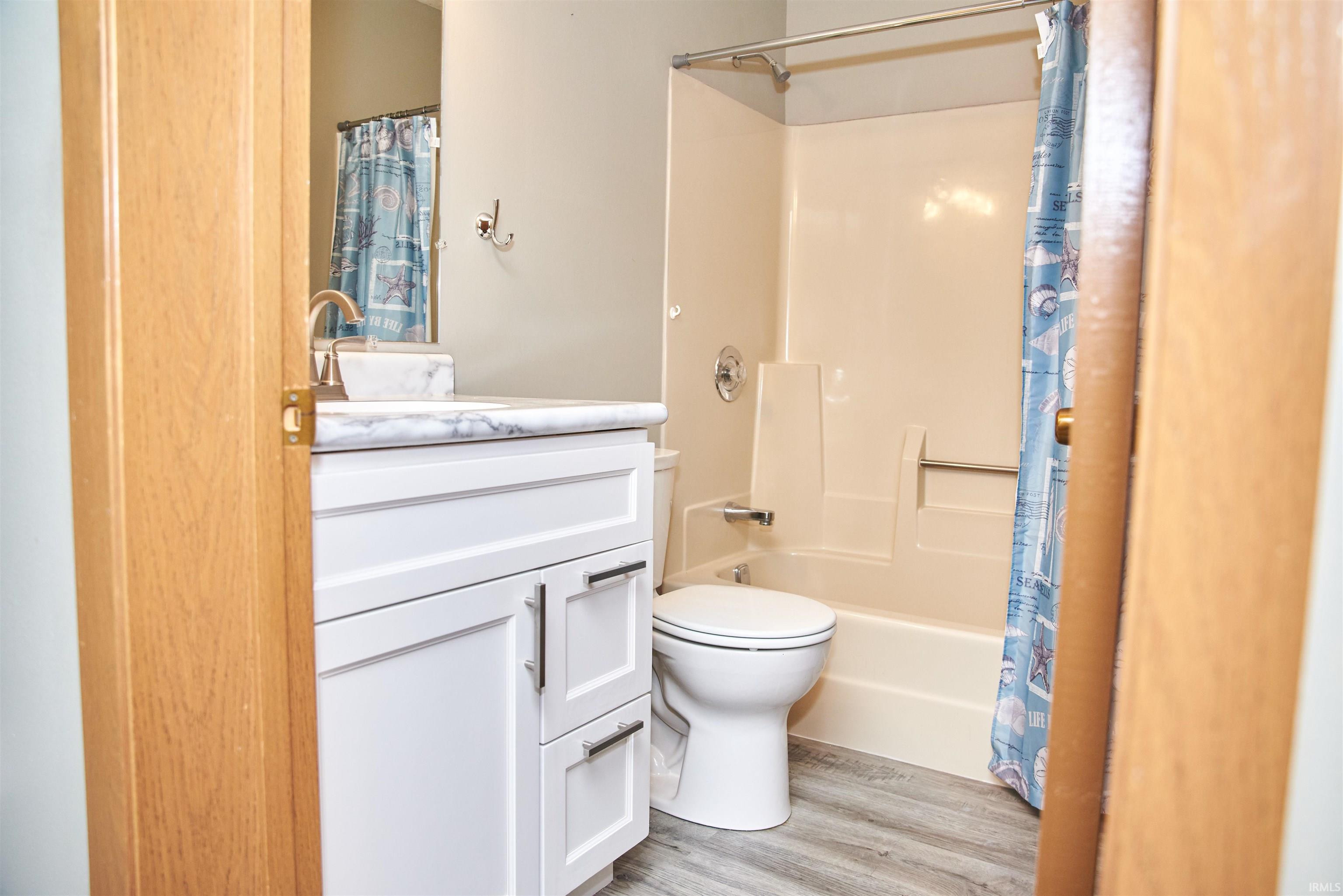 Bathroom featuring vanity, light wood finished floors, and shower / bath combo