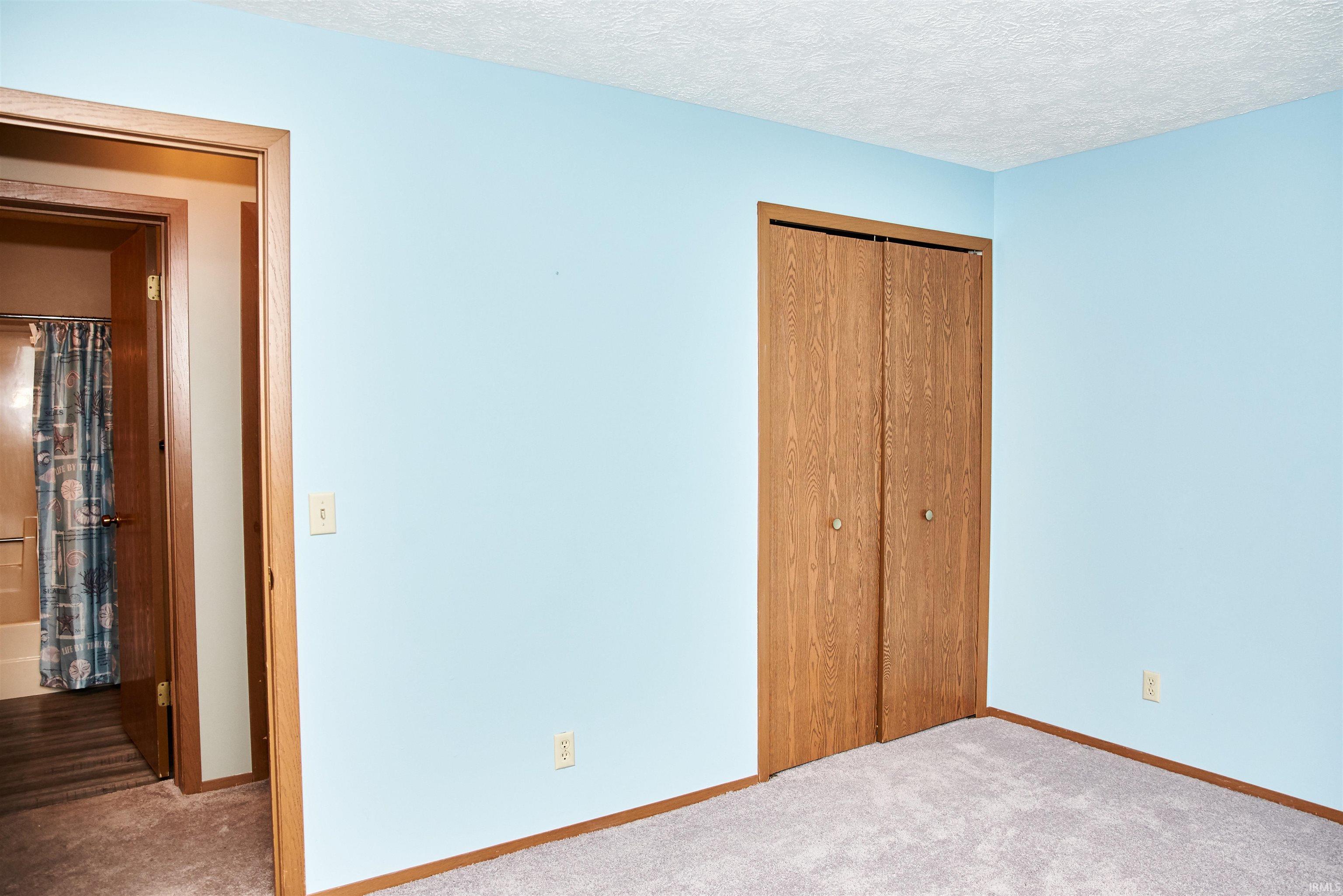 Unfurnished bedroom with carpet, a closet, and a textured ceiling