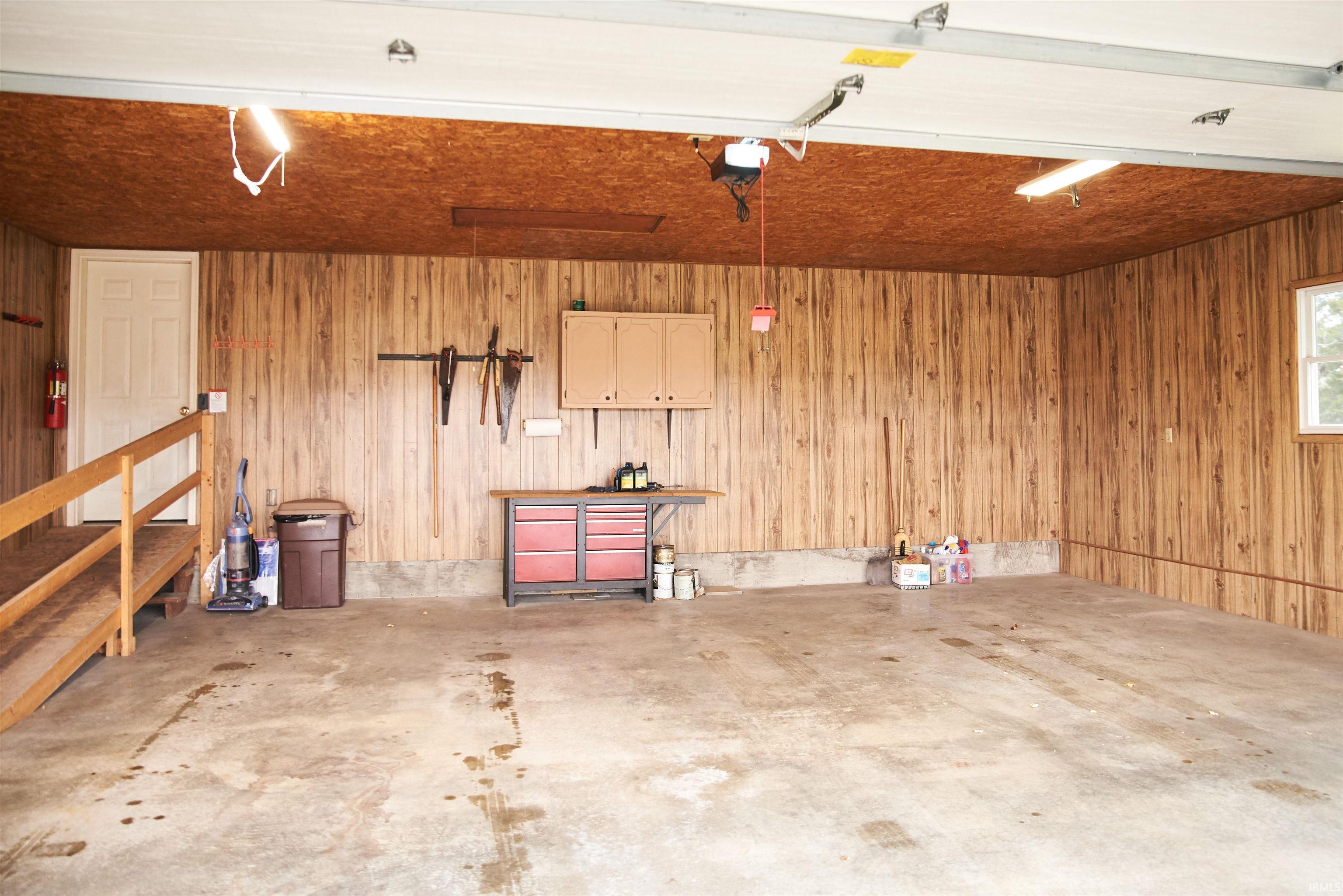 Garage with wooden walls and a garage door opener
