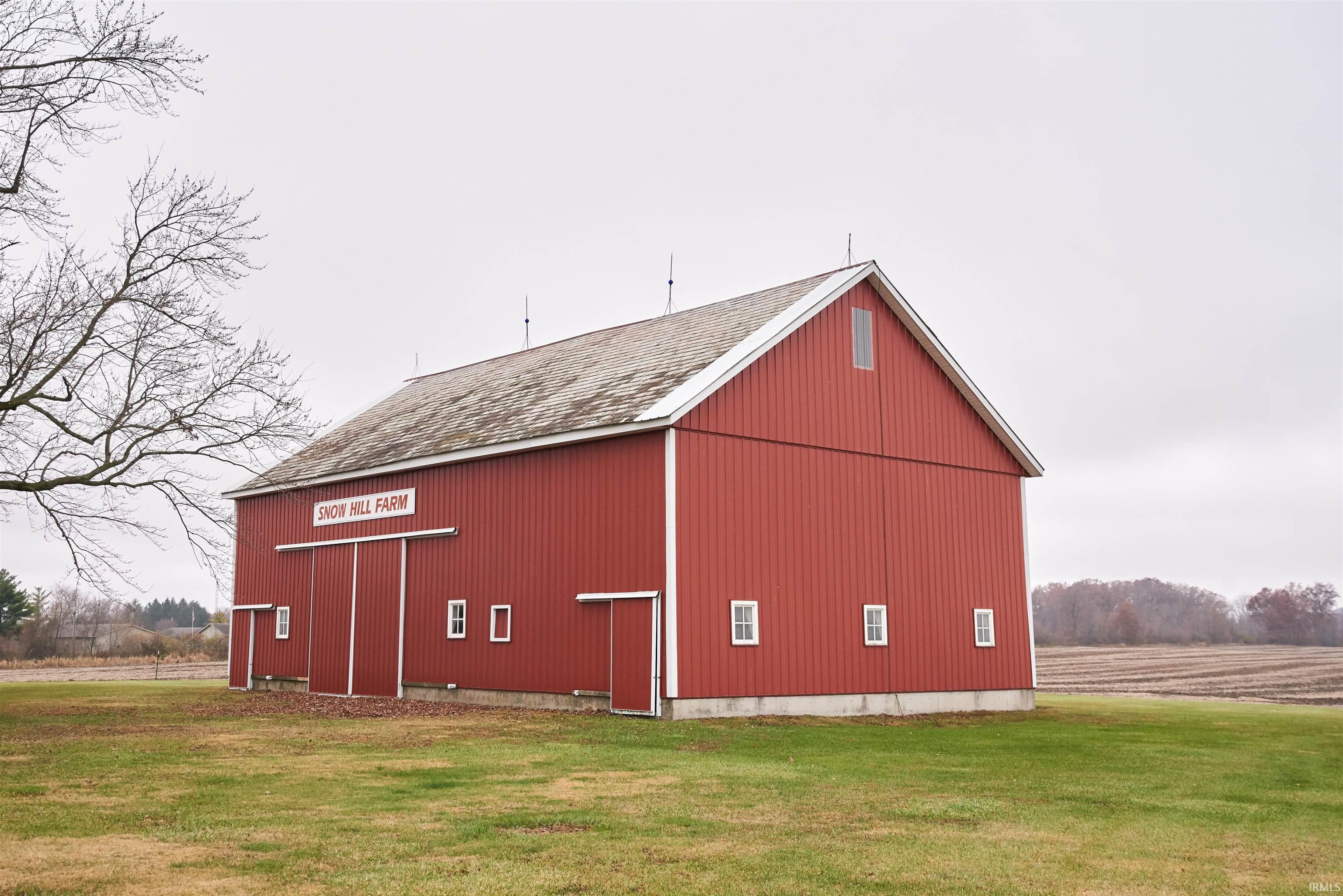 View of pole building featuring a lawn and a view of countryside