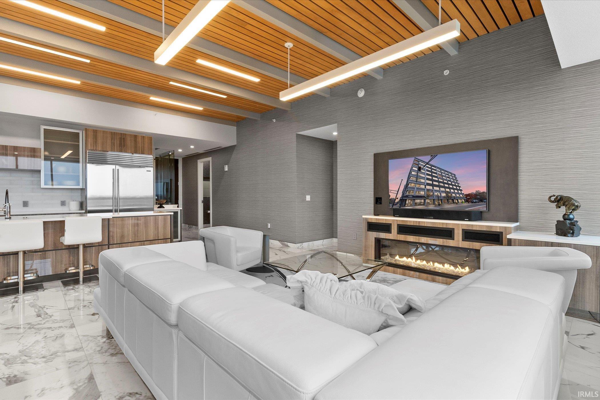 Cinema with light marble finish flooring, a wooden ceiling with exposed beams and a high ceiling