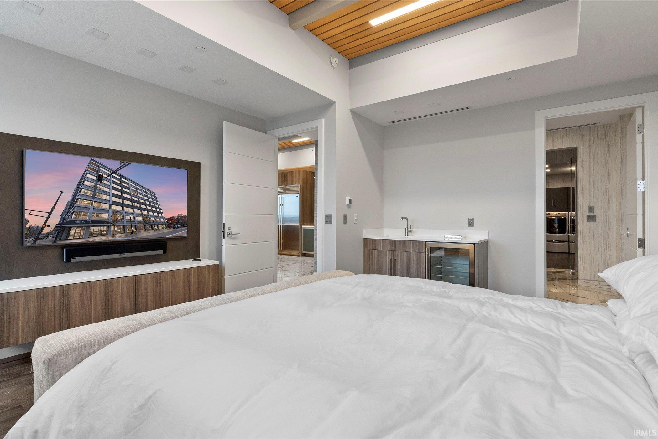 Bedroom featuring wet bar, built in refrigerator, and beverage cooler