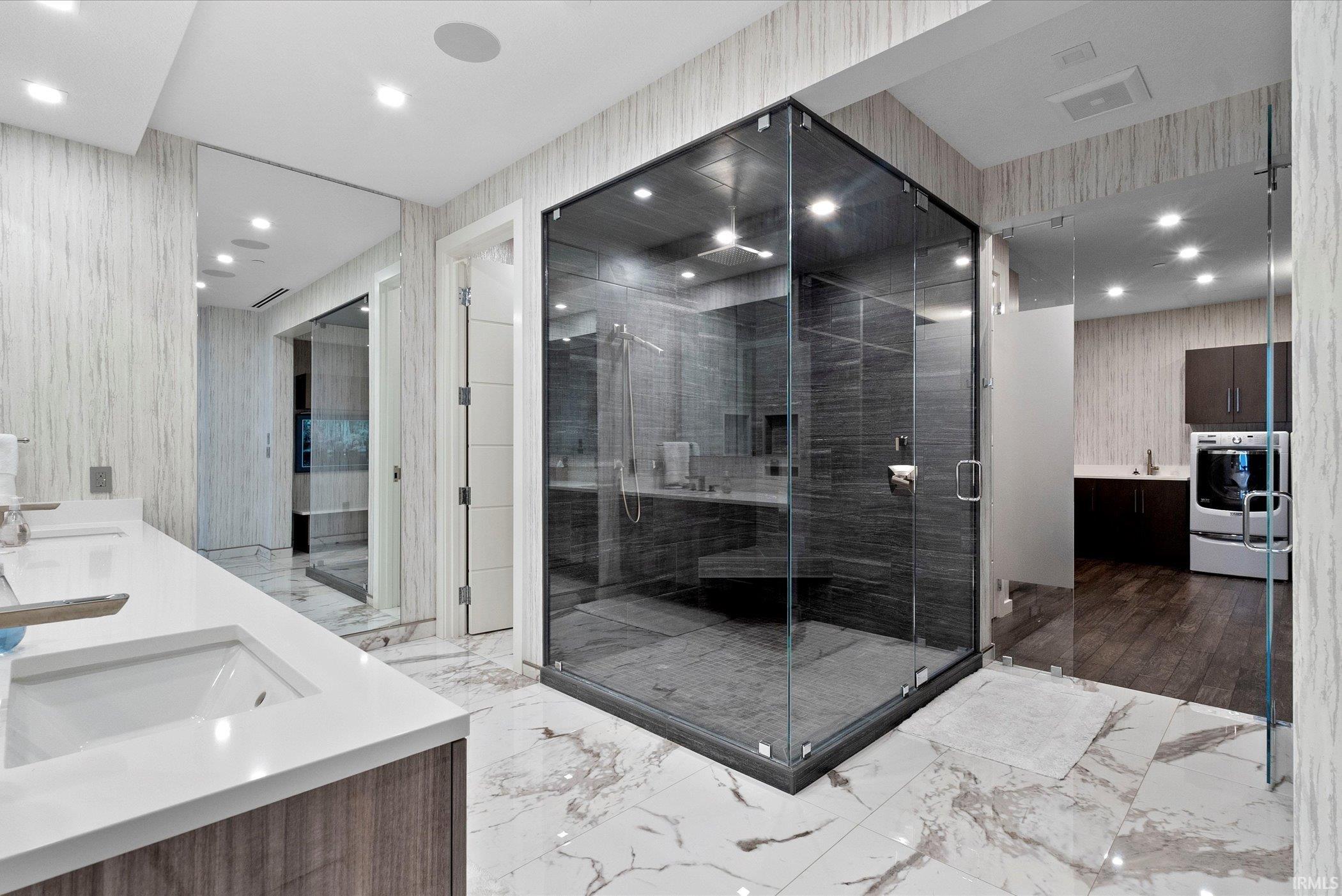 Full bathroom with double vanity, wallpapered walls, light marble finish flooring, a sauna / steam room, and recessed lighting