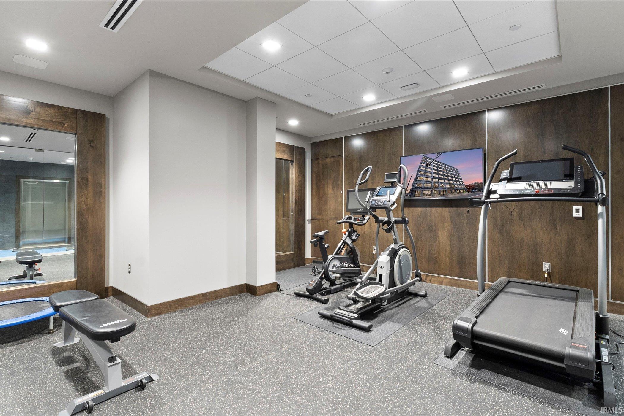 Workout area featuring recessed lighting and wooden walls