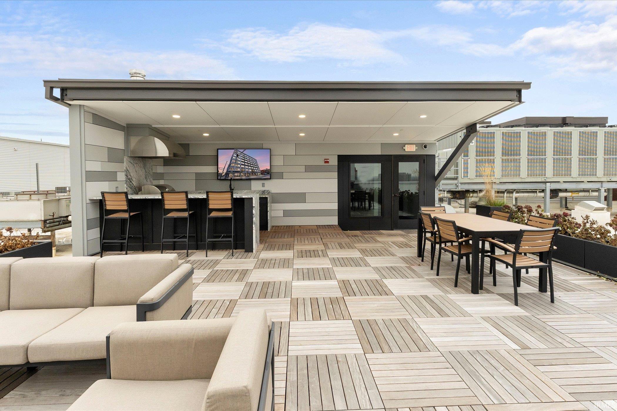 View of patio with outdoor lounge area, outdoor dining area, a roof deck, and french doors