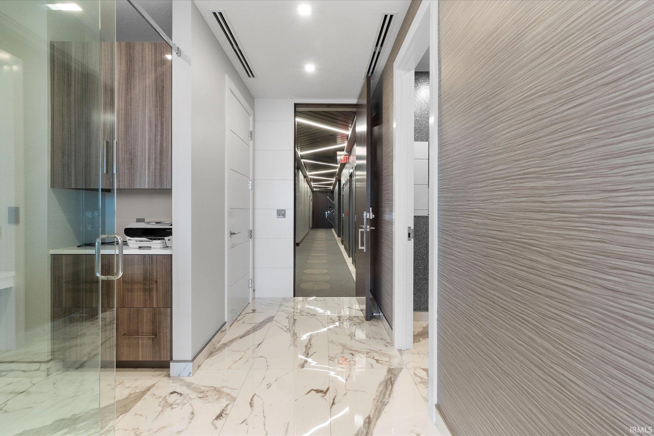 Hallway featuring light marble finish flooring and recessed lighting
