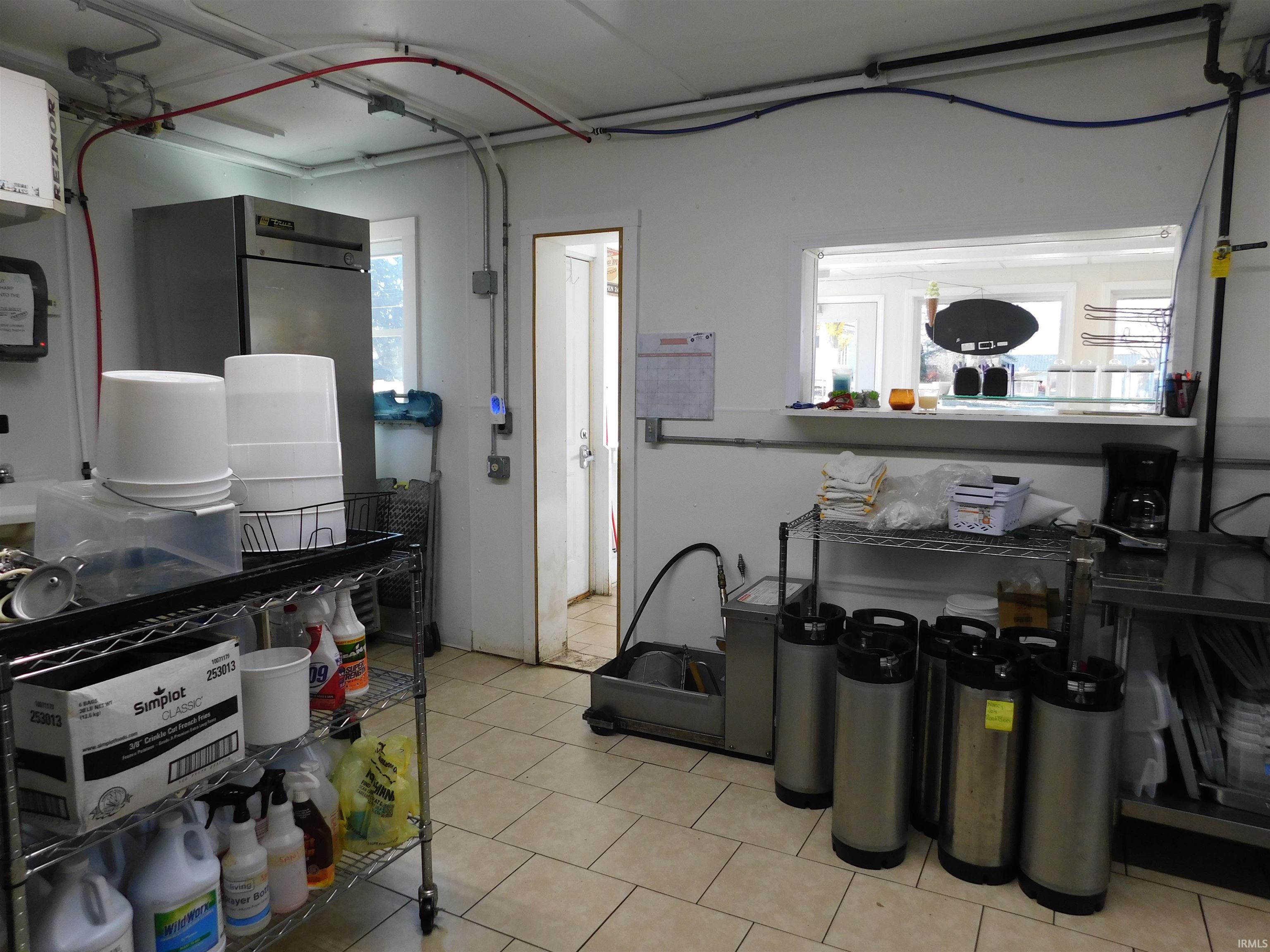 Kitchen featuring freestanding refrigerator and light tile patterned floors