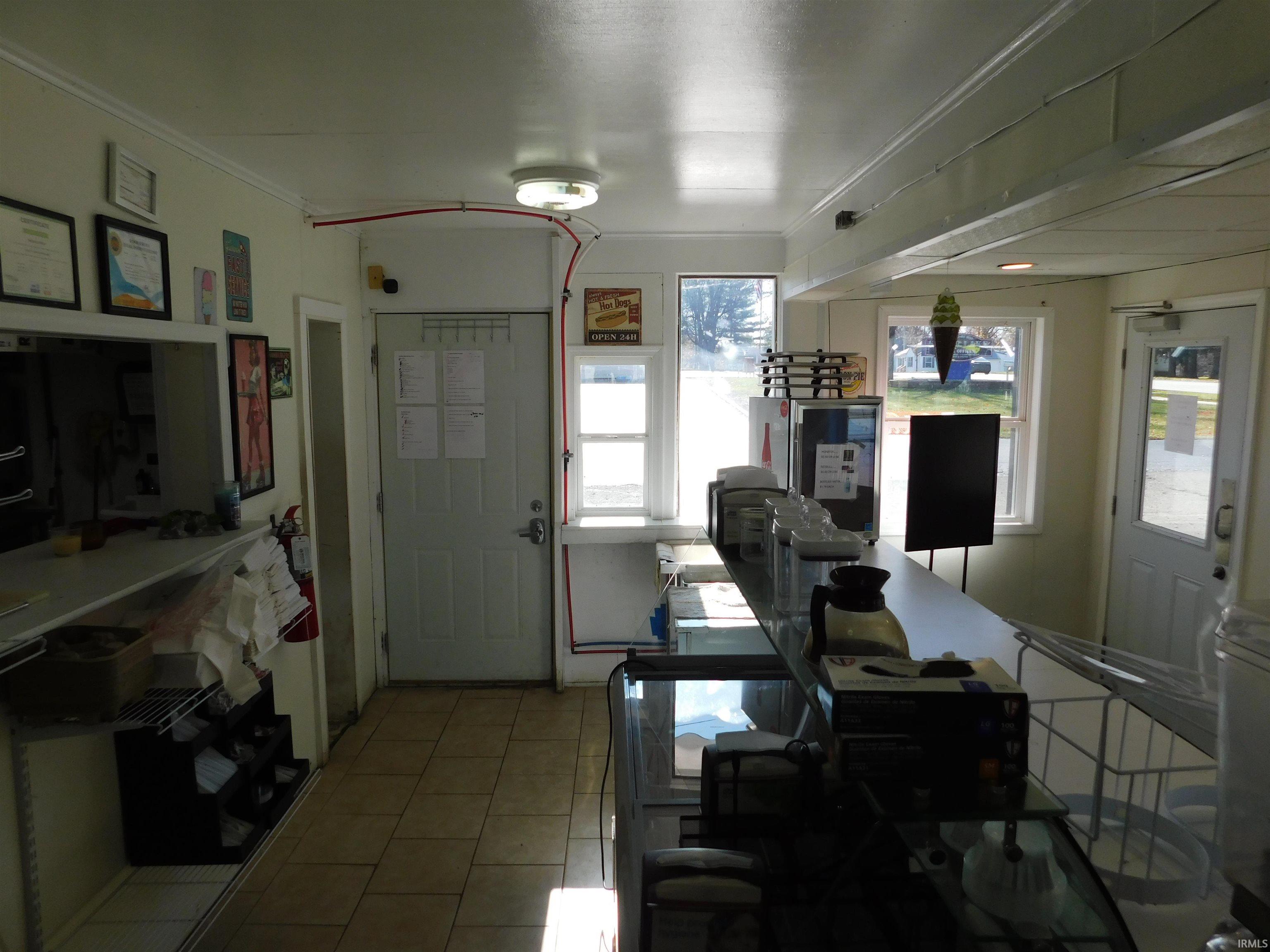 Dining room featuring a desk, light tile patterned floors, and ornamental molding