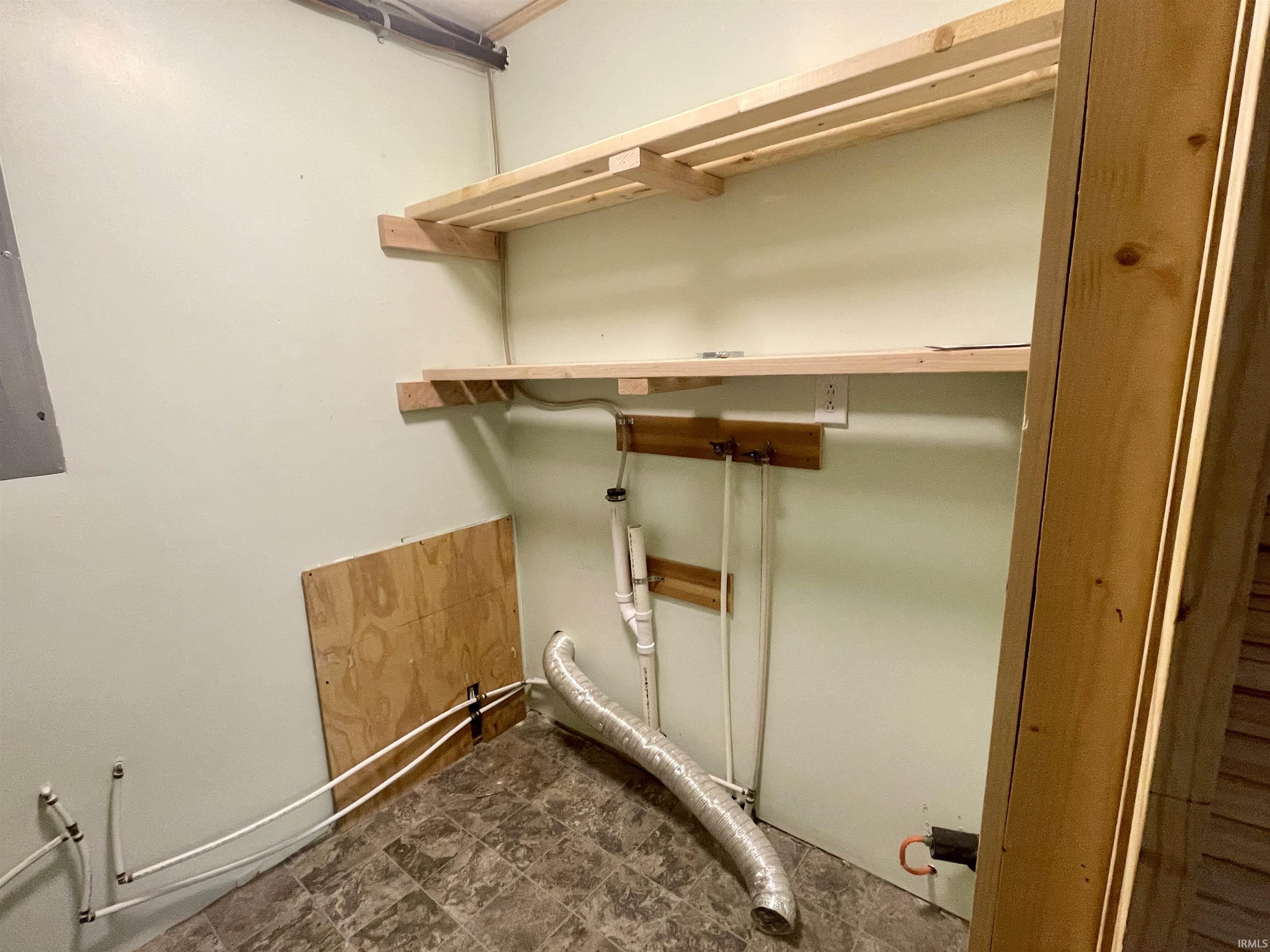 Laundry area with dark flooring