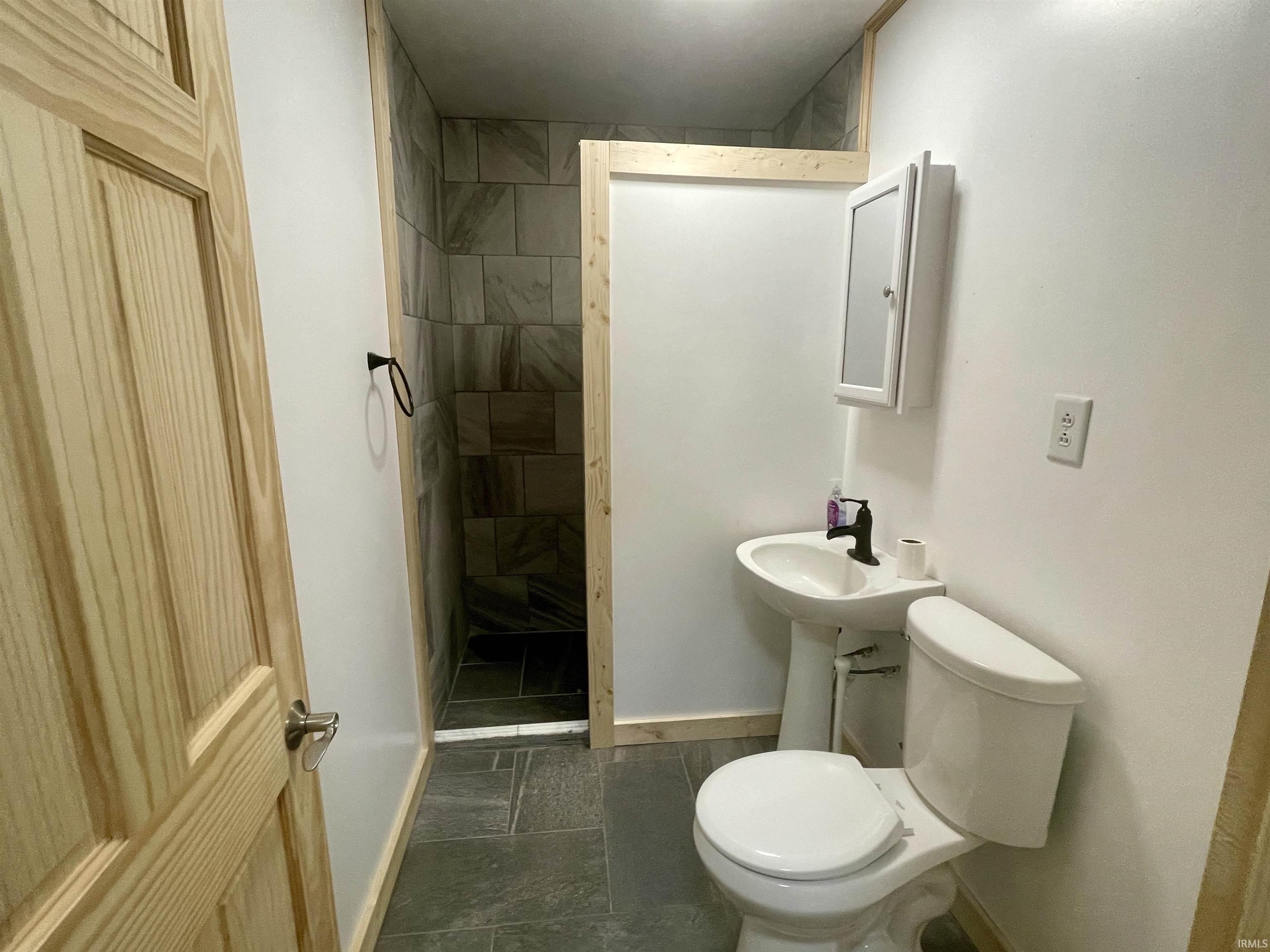 Bathroom with baseboards and tiled shower