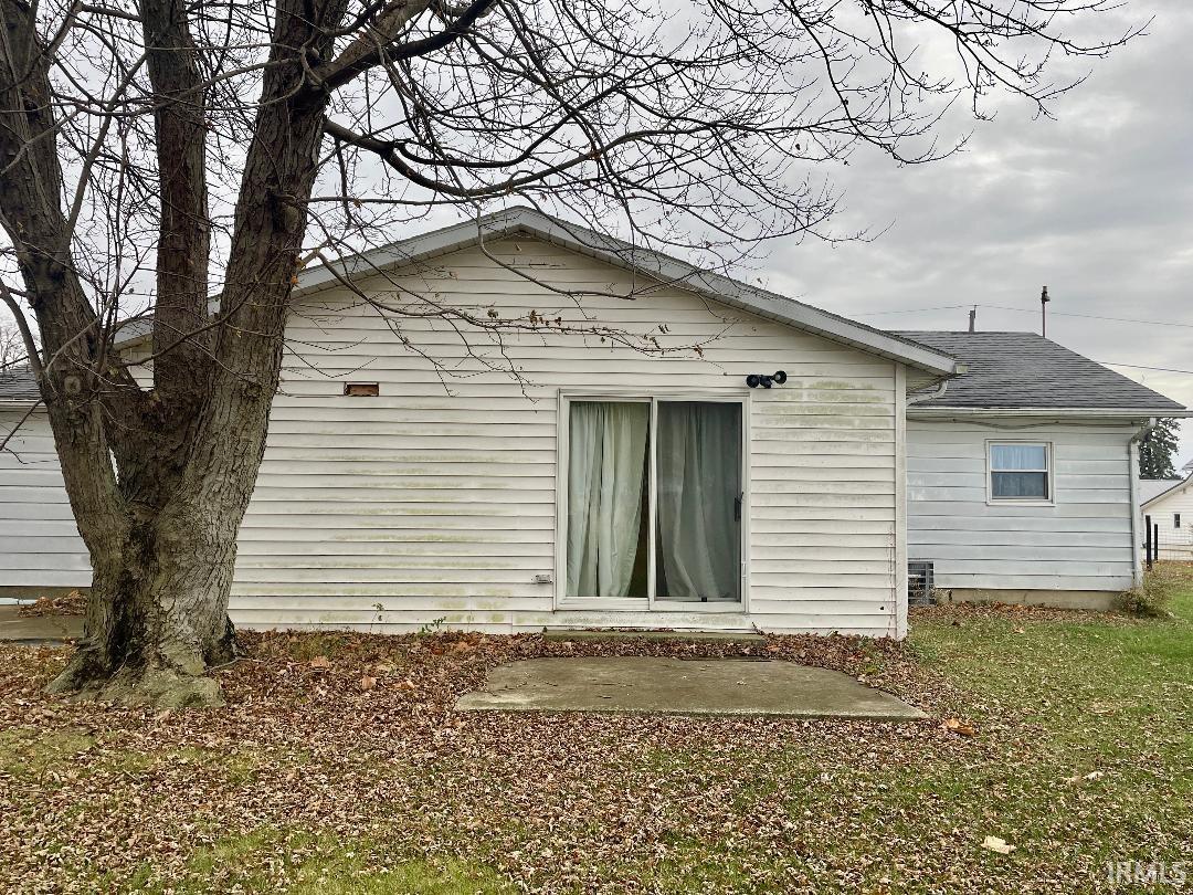 Rear view of property with roof with shingles and a patio area