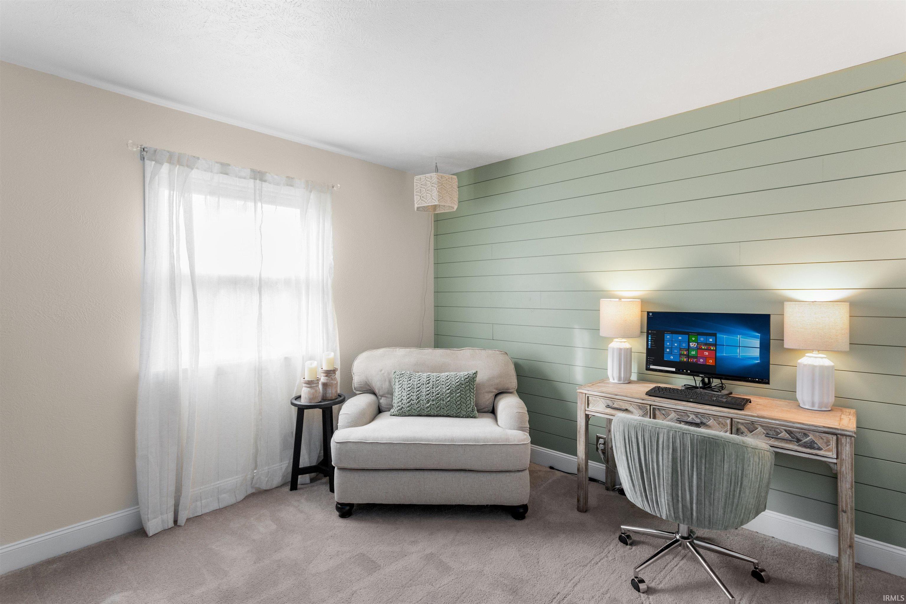 Home office featuring wooden walls and carpet flooring