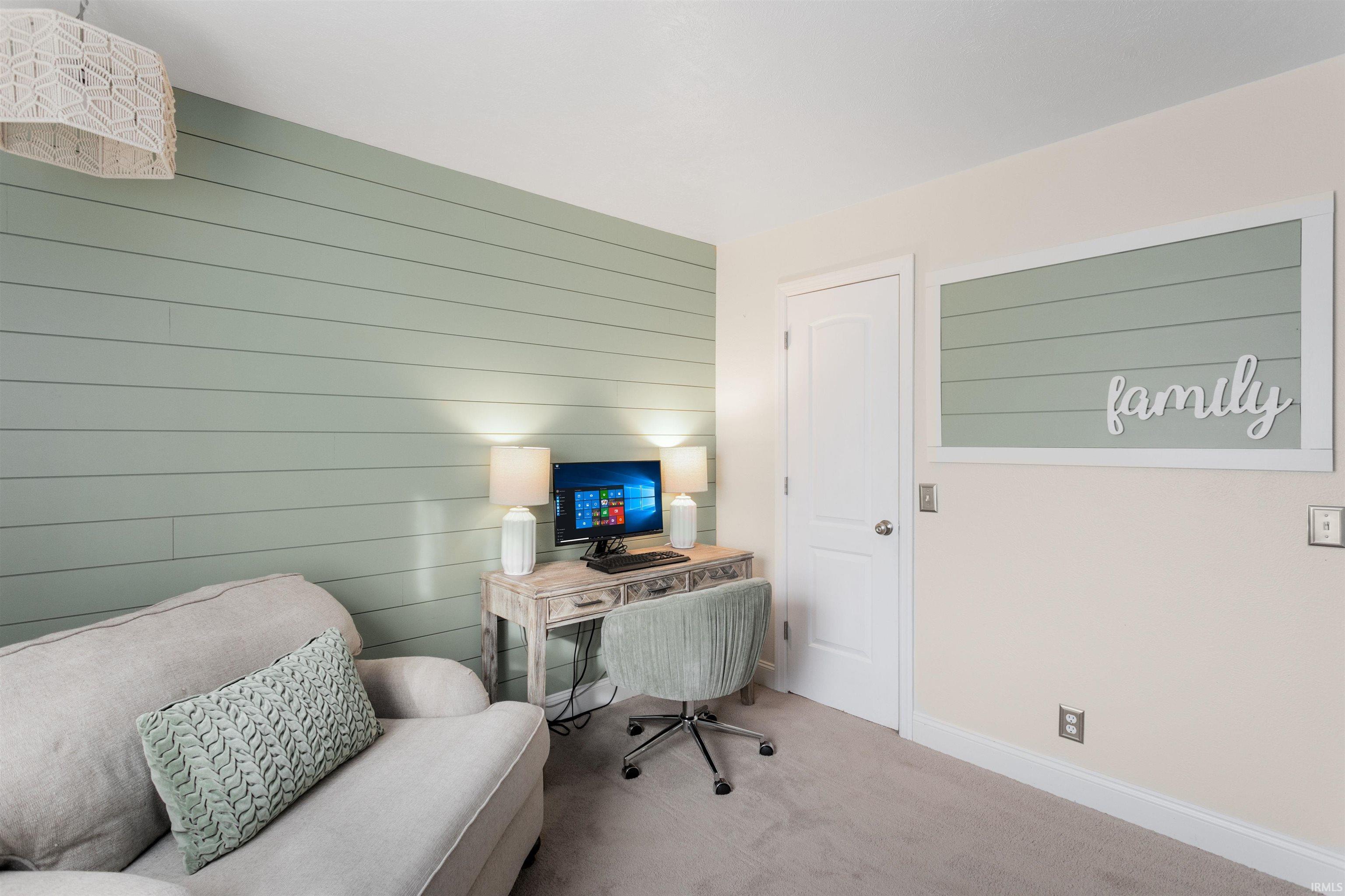 Carpeted office featuring wood walls and an accent wall