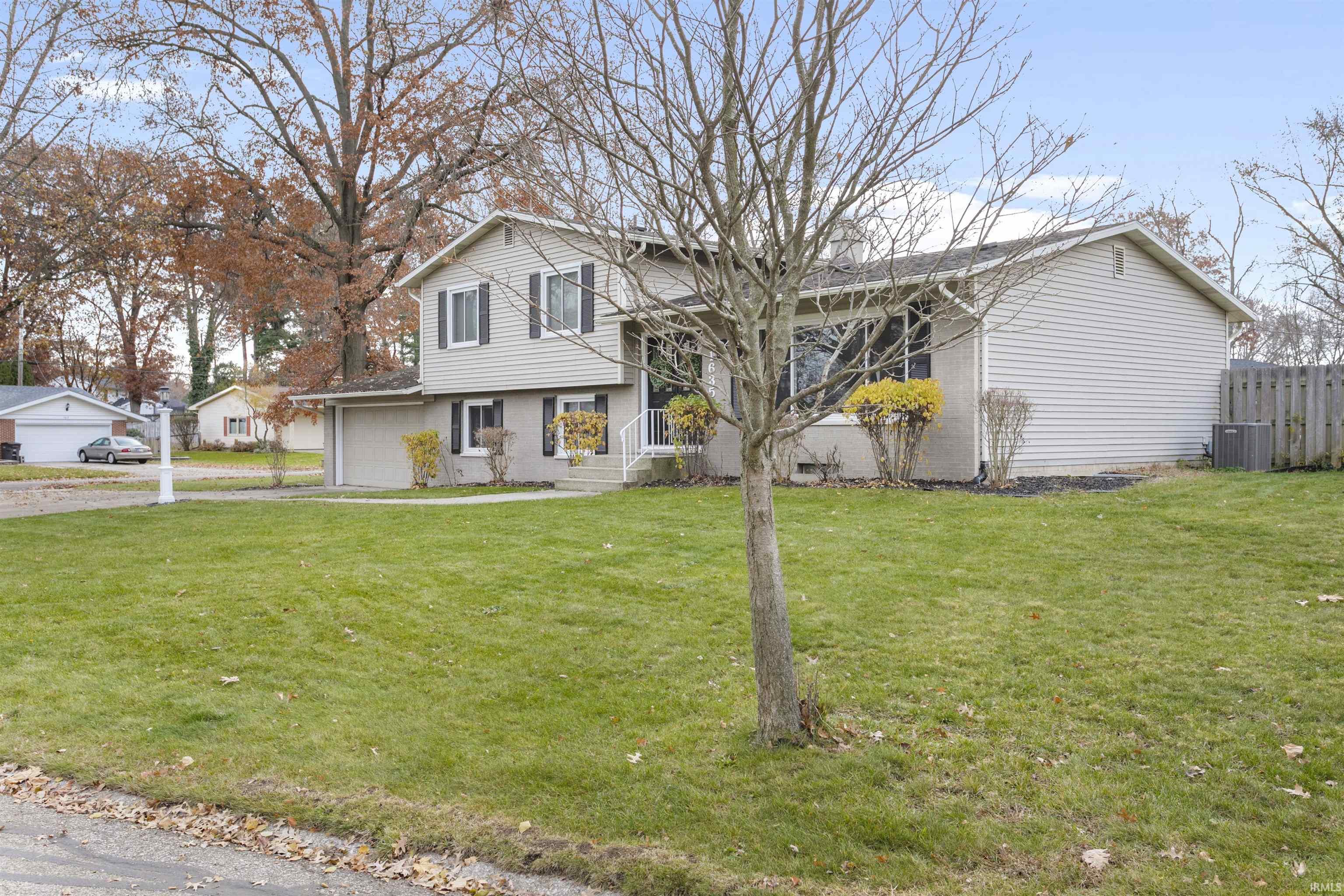 View of front facade featuring a garage and driveway